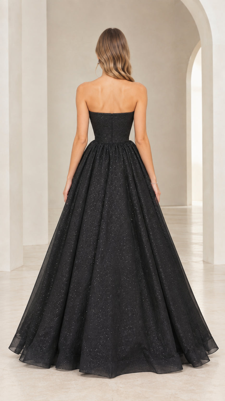 Back view of black strapless floor-length glitter ball gown