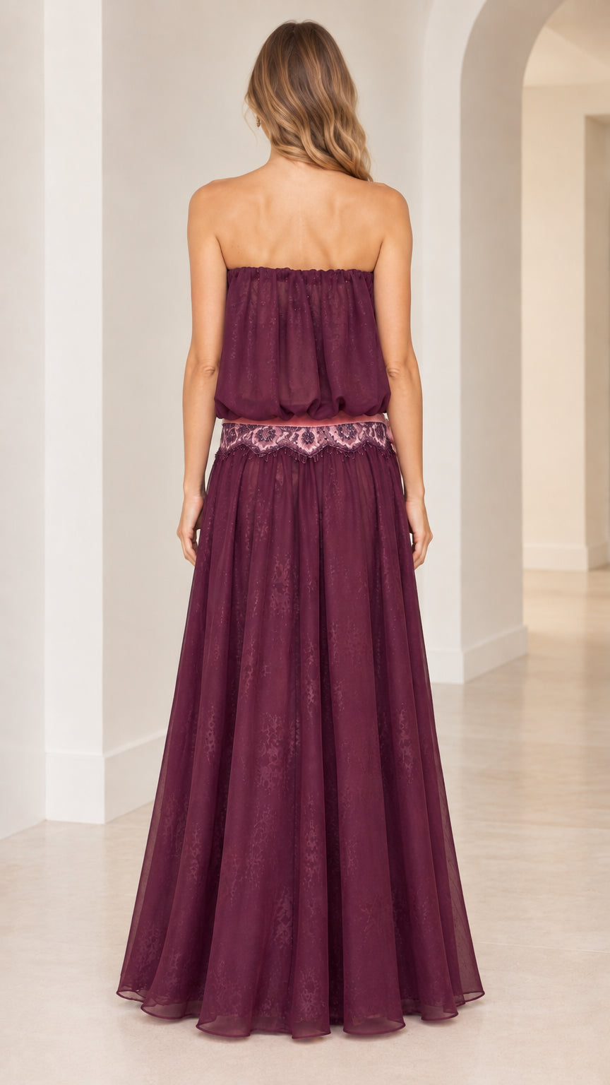 Back view of woman in flowing strapless plum purple evening gown