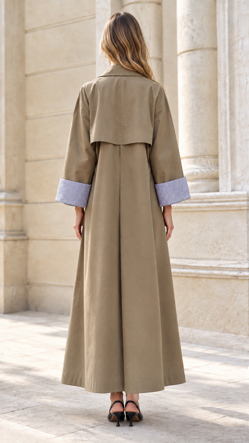 Back view of model in khaki duster coat highlighting the storm flap detail