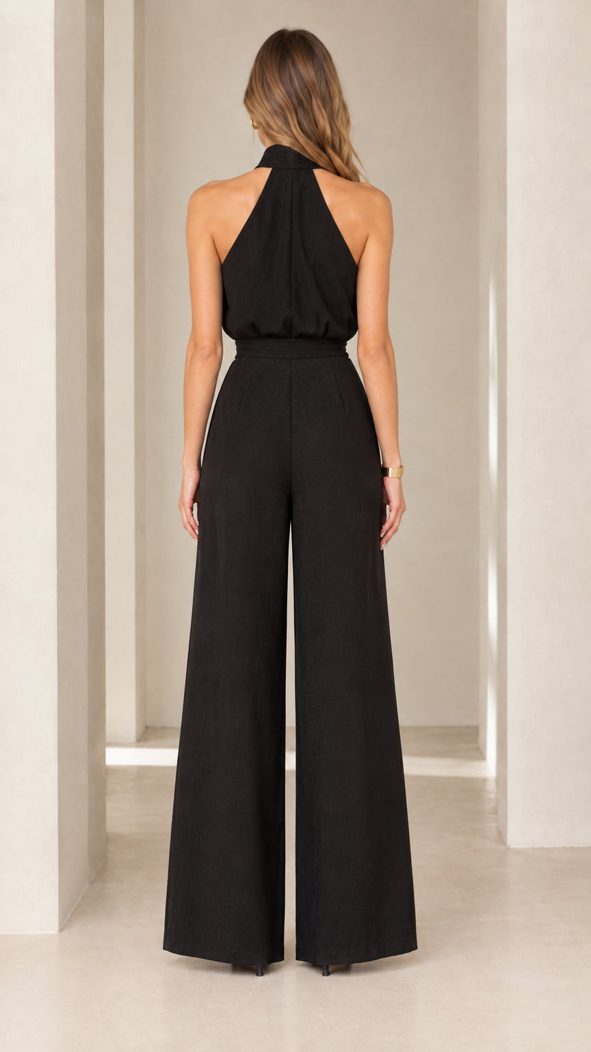 Back view of model wearing black halter neck evening jumpsuit