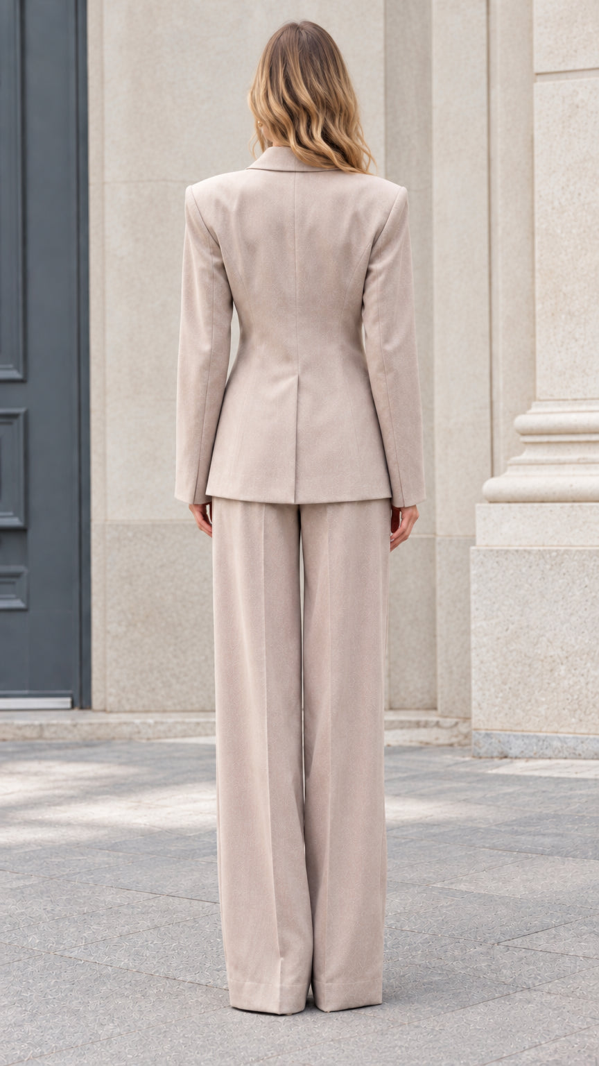 Back view of model wearing taupe tailored blazer and wide leg trousers