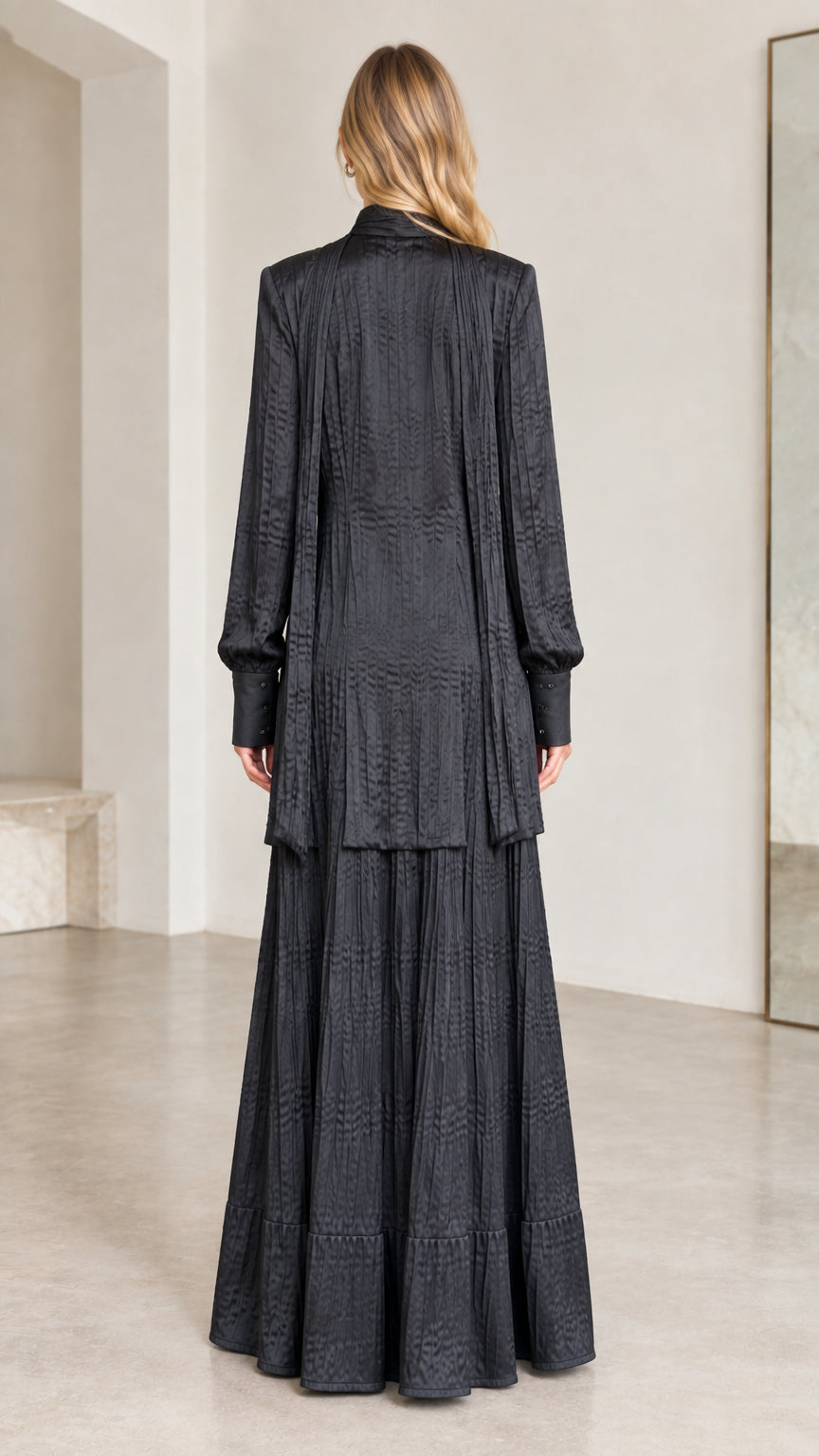 Back view of black pleated maxi dress with matching draped cardigan layer