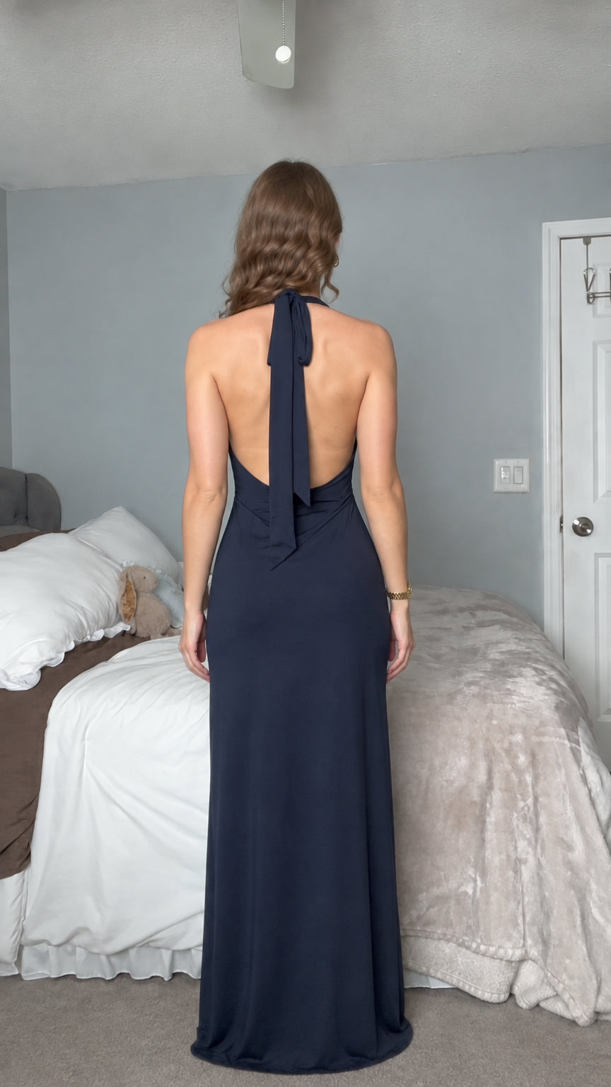 Back view of woman wearing navy blue halter neck gown showing open back detail