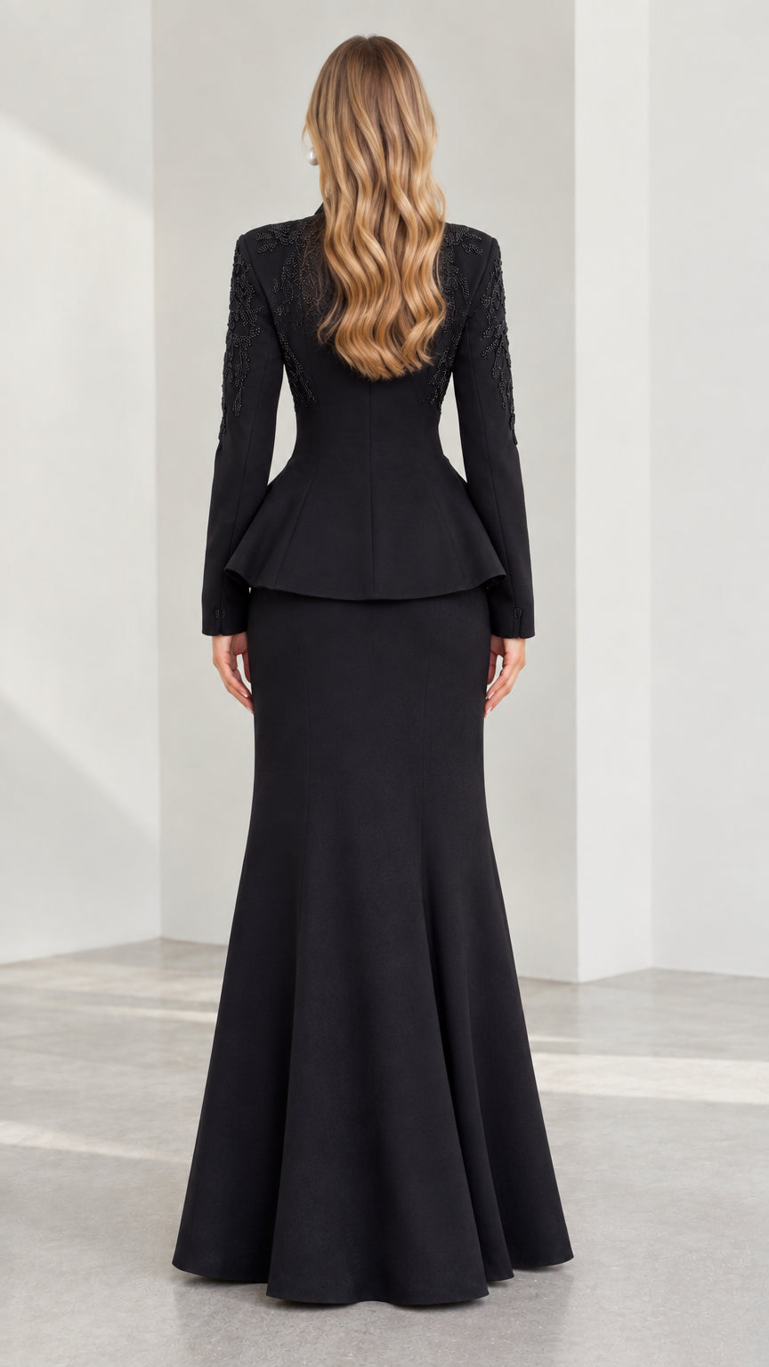 Back view of black tailored peplum jacket and floor-length mermaid skirt