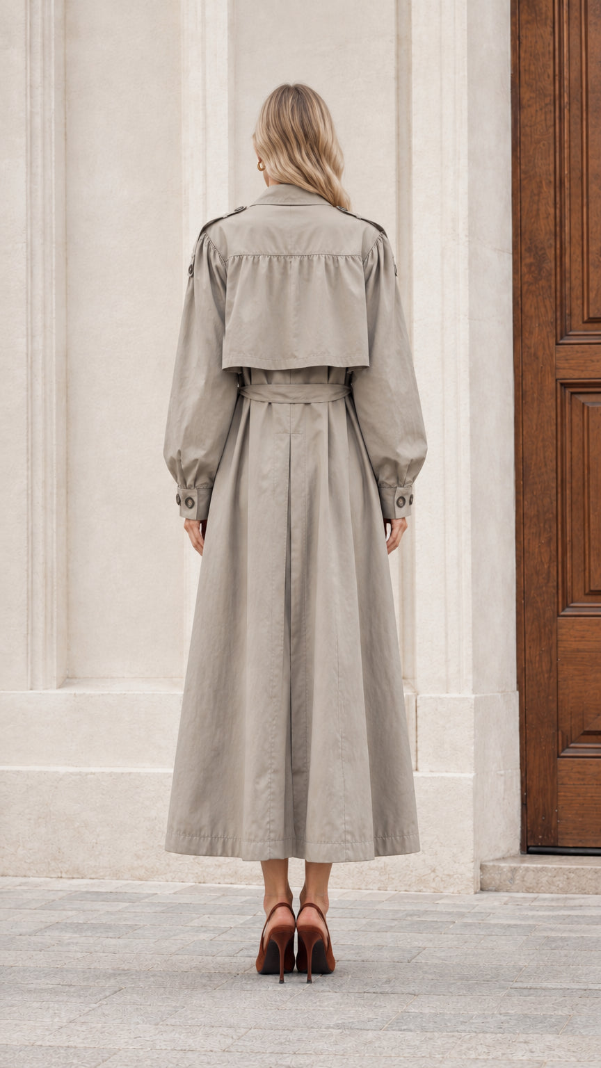 Back view of women's long grey trench coat showing storm flap and back vent