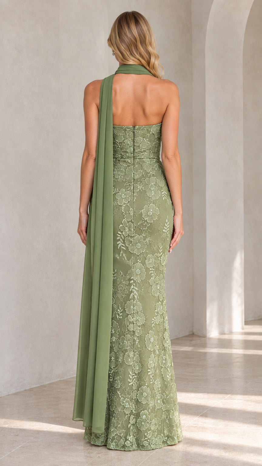 Back view of sage green strapless evening gown highlighting fit and long drape