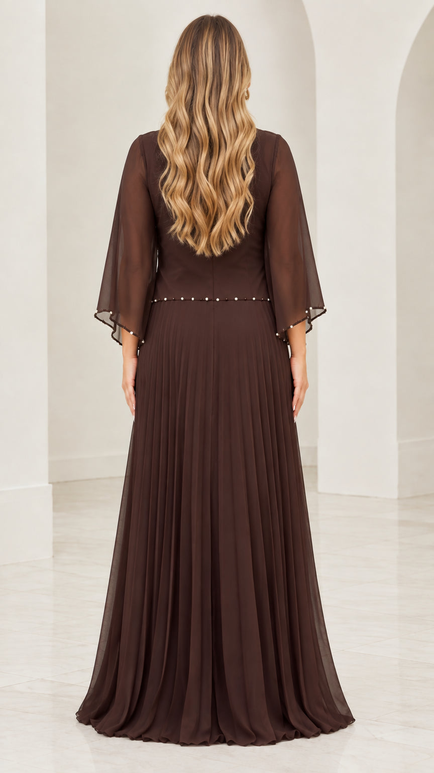 Back view of woman wearing dark brown floor-length pleated evening dress