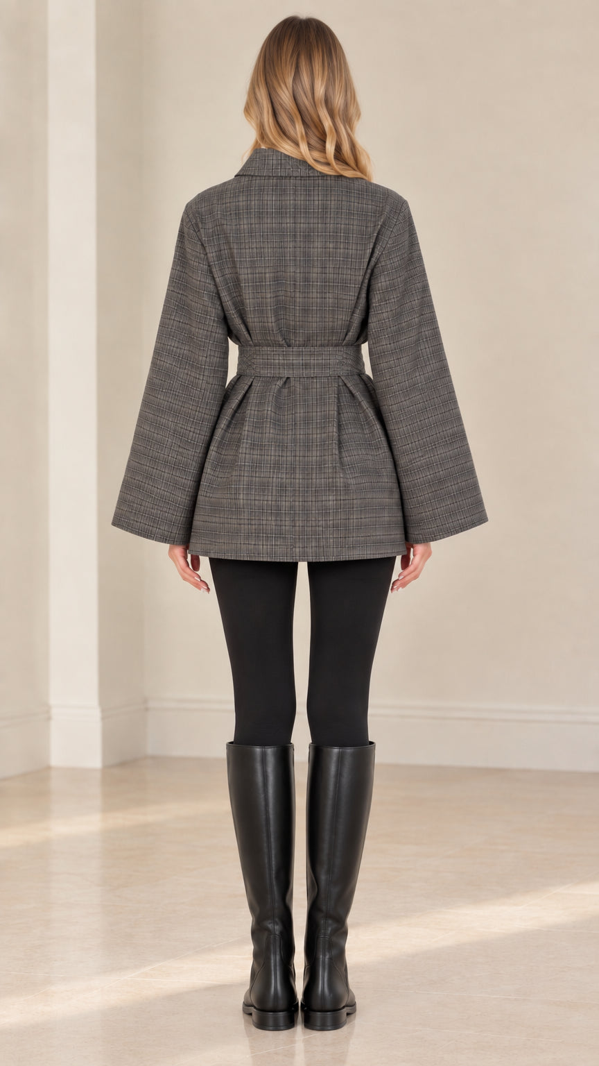 Back view of woman wearing grey plaid belted jacket showing back pleat and silhouette