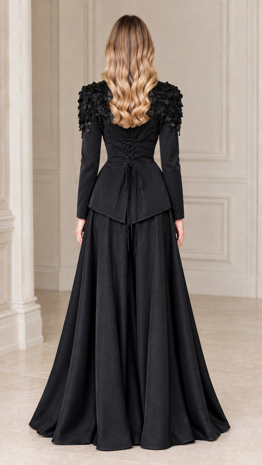 Back view of black evening blazer showing lace-up corset detail and flowing maxi skirt