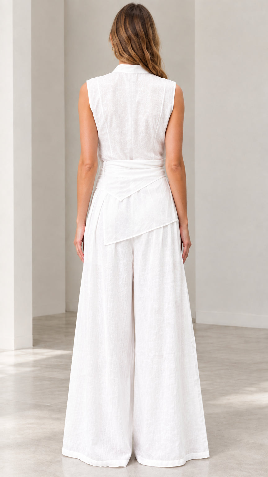 Back view of woman wearing white sleeveless high-waist wide-leg jumpsuit