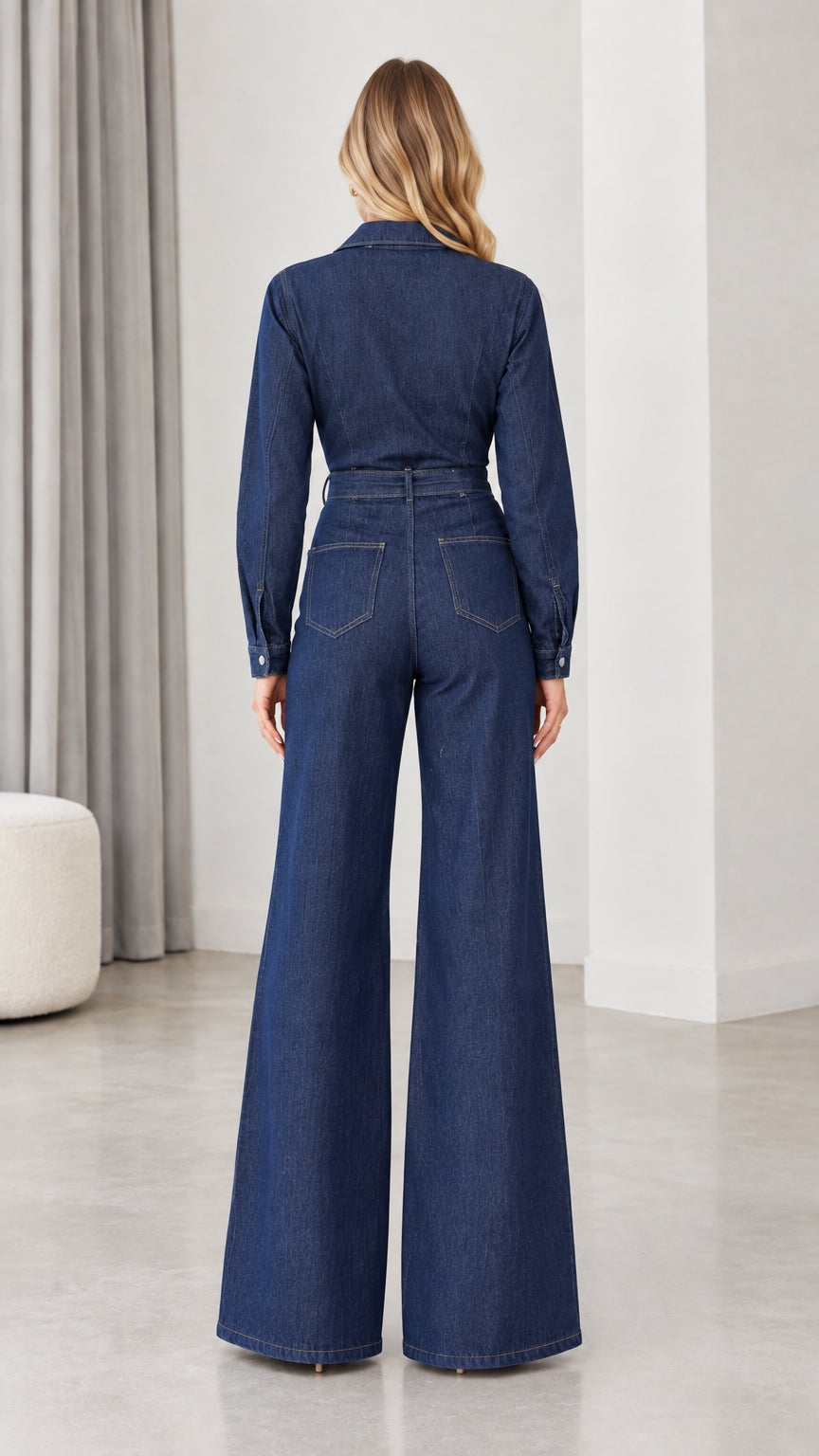 Back view of woman wearing dark blue denim jumpsuit showing back pockets