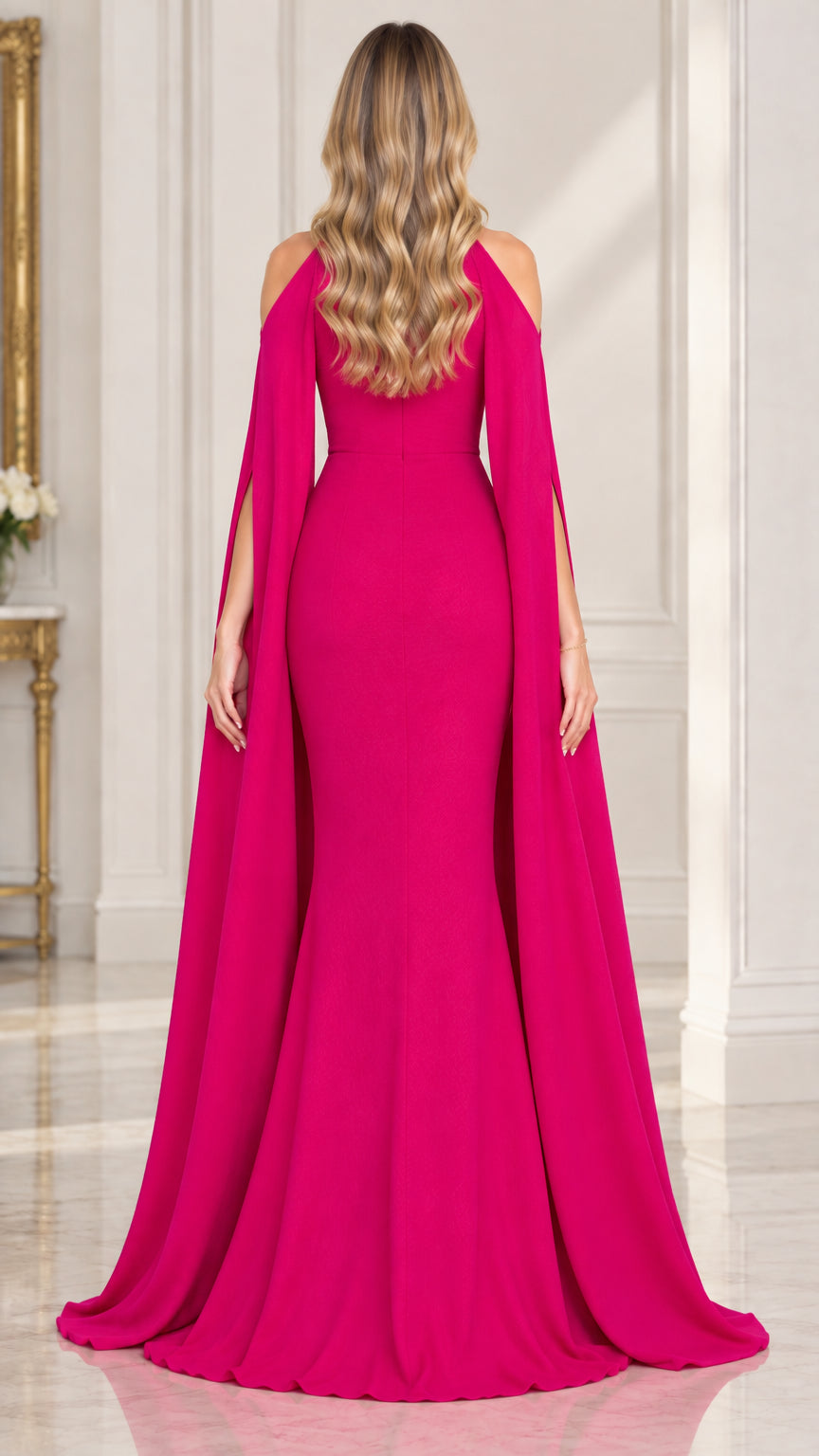 Back view of woman wearing fuchsia floor length evening dress with flowing cape