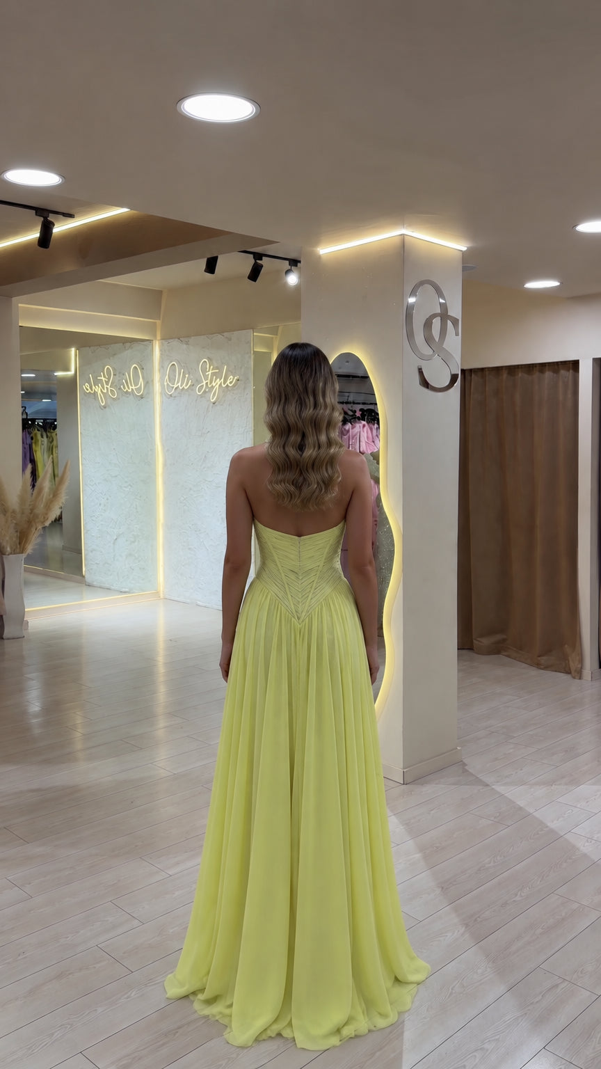Back view of model in yellow halter open-back floor-length gown