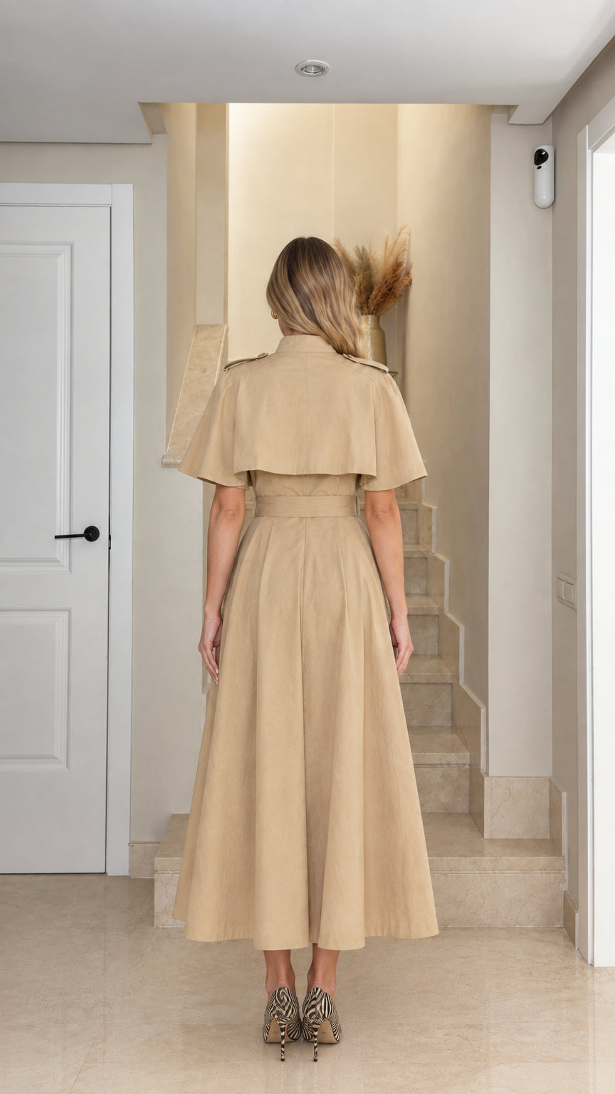 Back view of model wearing khaki capelet midi trench dress