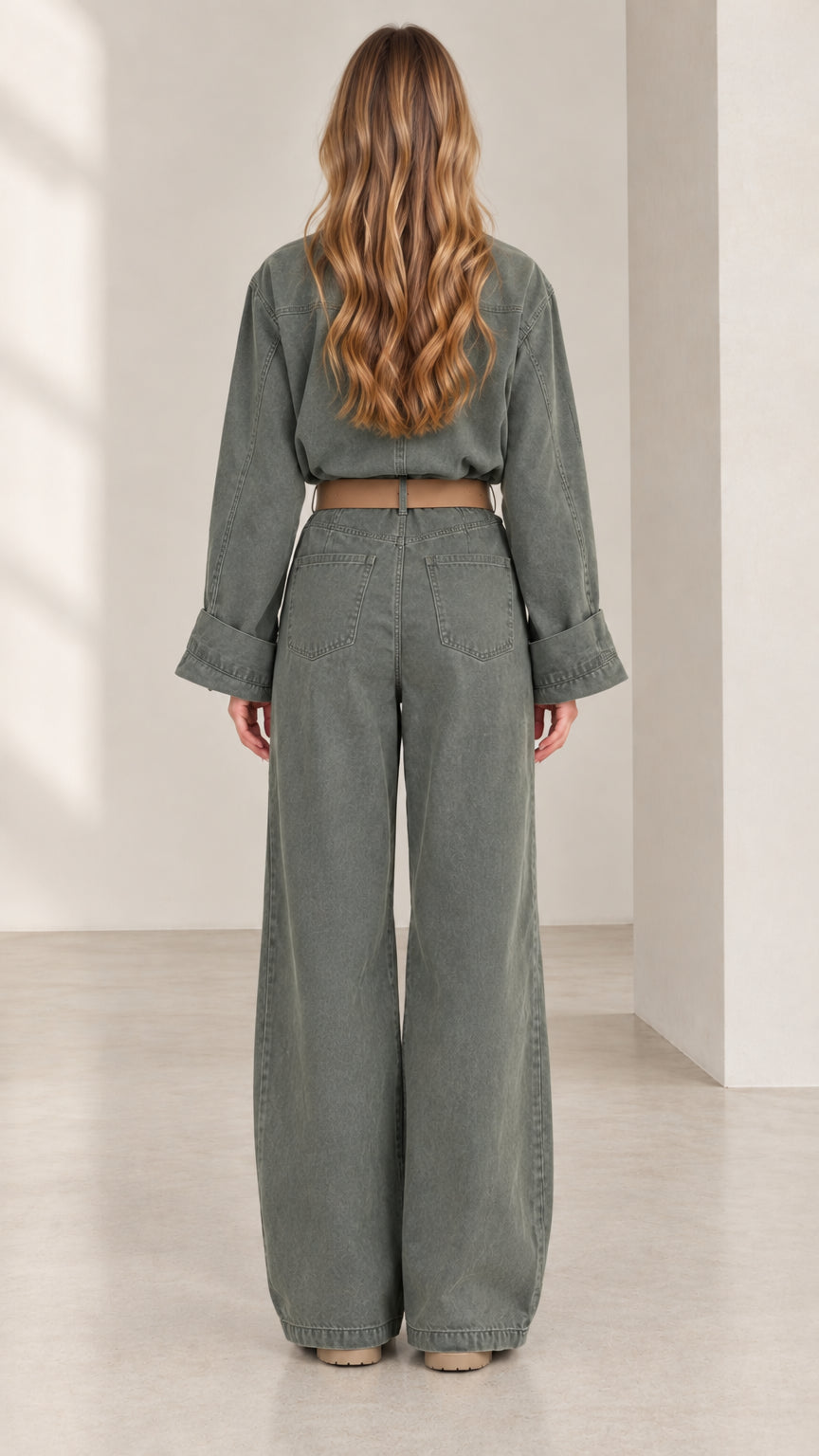 Back view of women's olive green long sleeve jumpsuit with patch pockets and belted waist