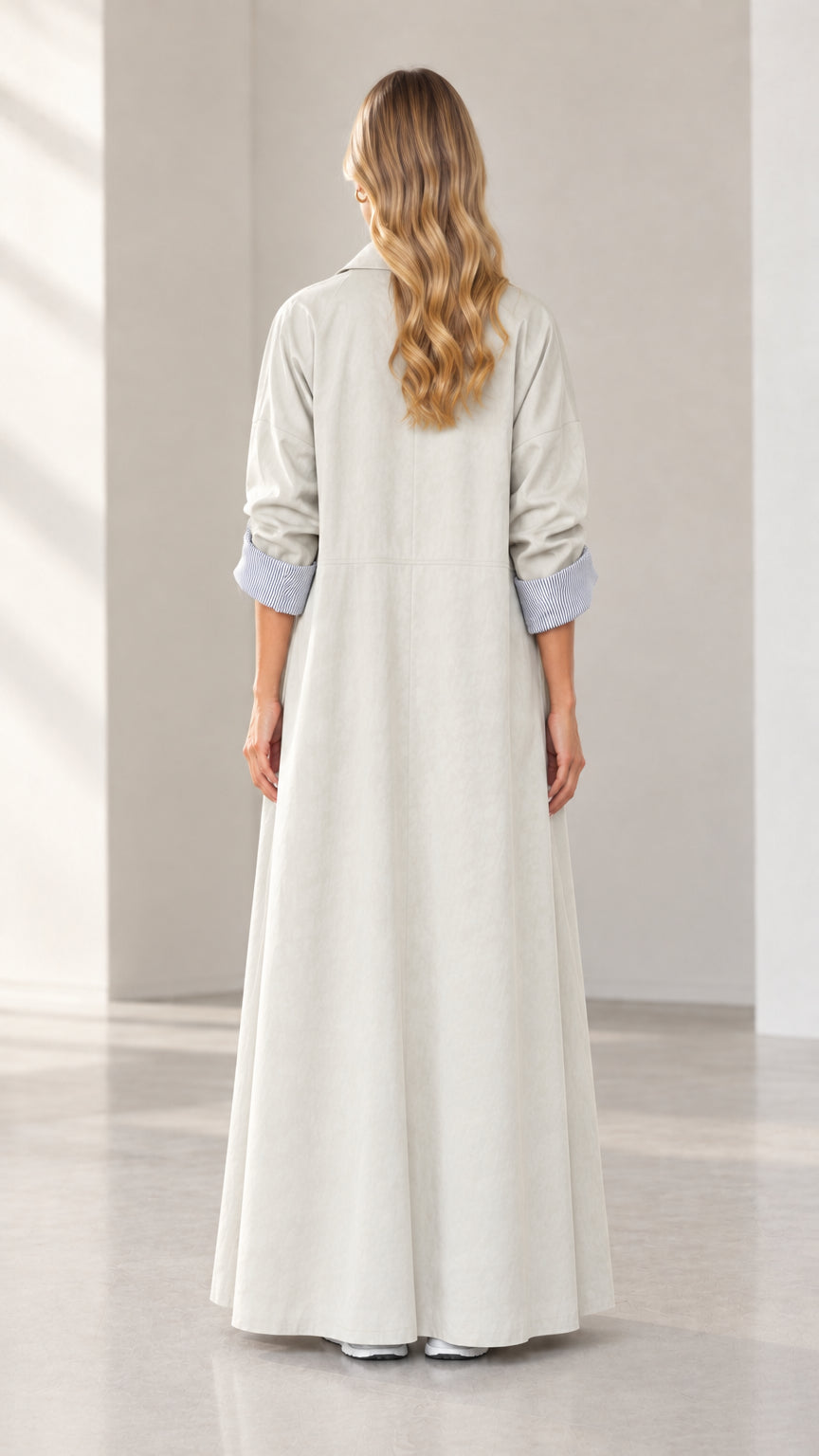 Back view of woman wearing elegant light grey maxi duster coat