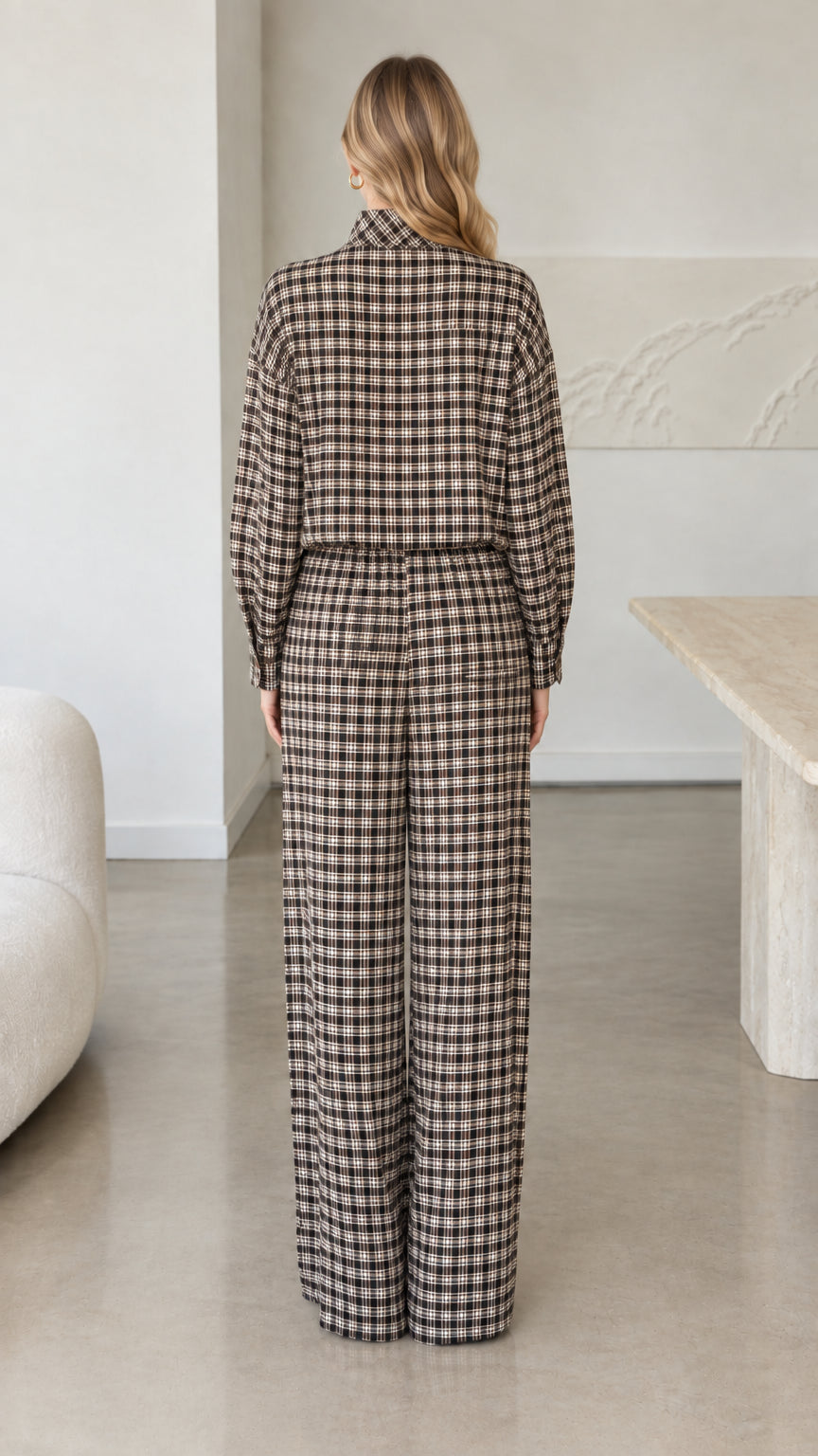 Back view of woman wearing long sleeve brown plaid top and matching trousers