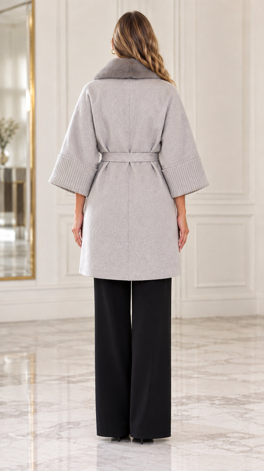 Back view of model showcasing the tailored fit of the light grey belted coat