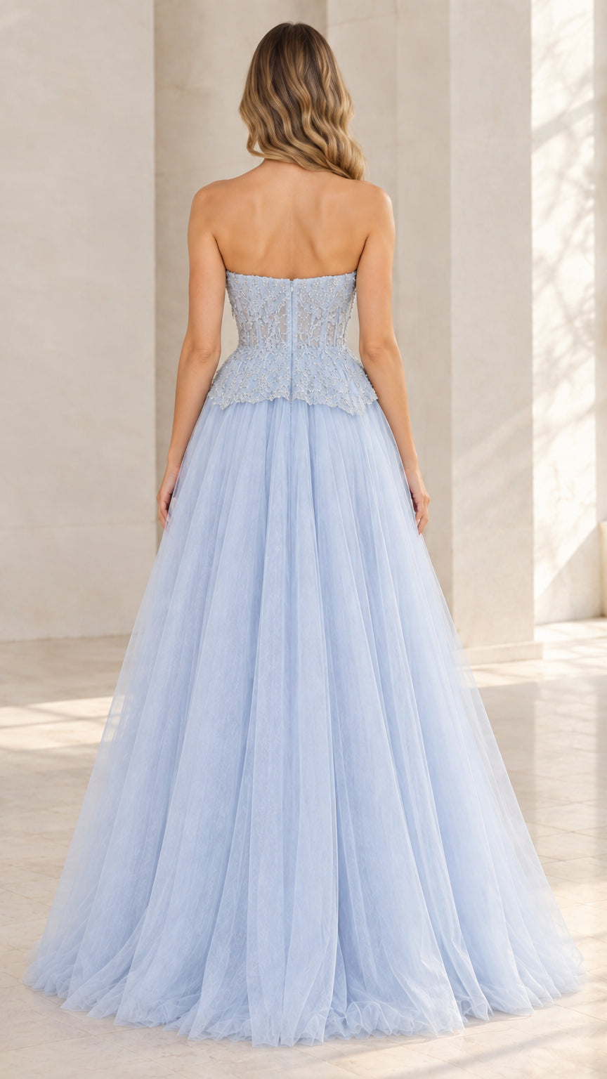 Back view of model wearing light blue strapless tulle ball gown
