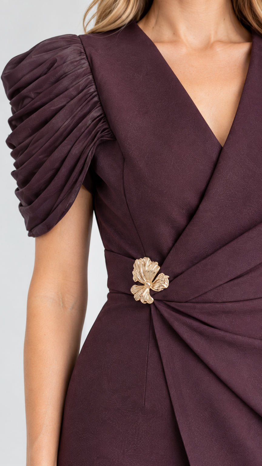 Close-up detail of V-neckline, gathered waist brooch, and micro-pleated shoulder sleeve
