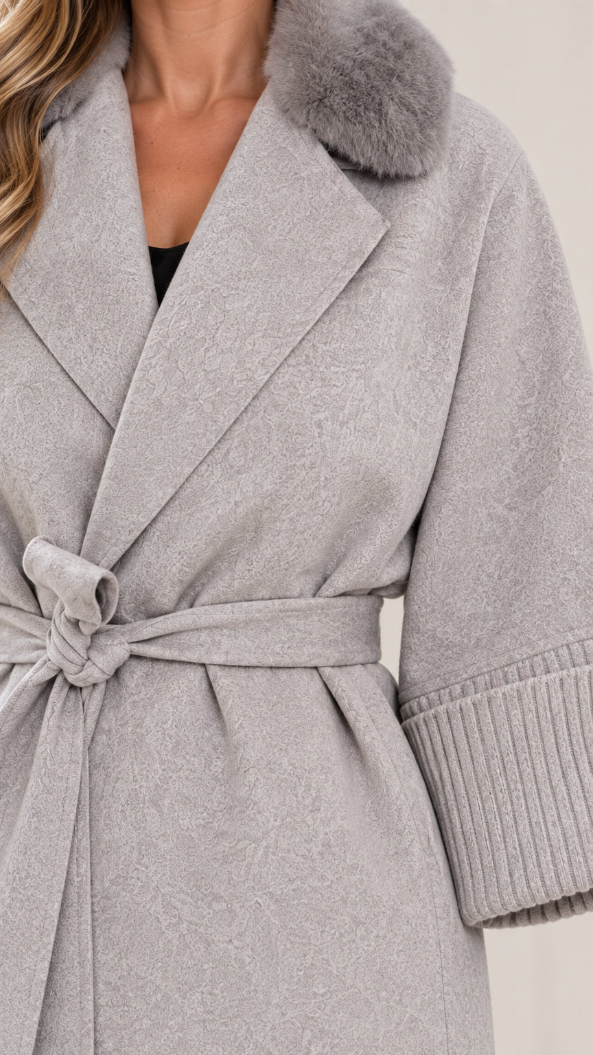 Close-up detail of faux fur collar, notched lapel, tie belt, and ribbed cuff in light grey