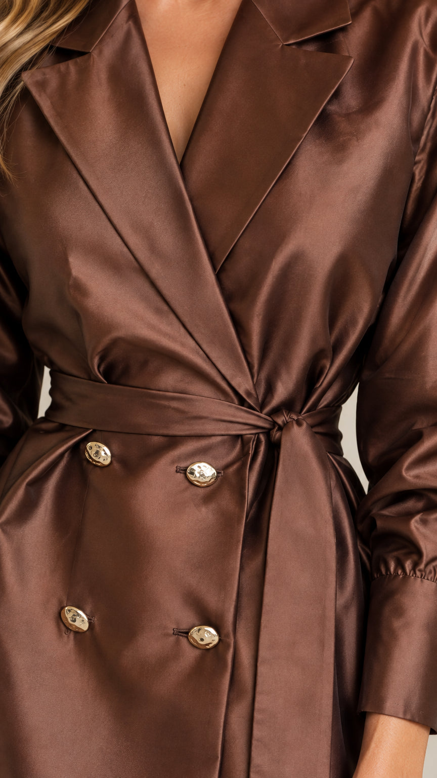Close-up detail of chocolate brown satin blazer lapel, buttons, and tie belt