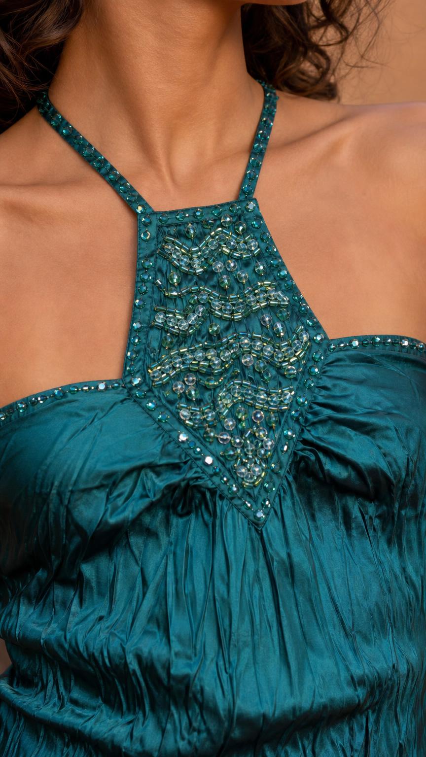 Close-up detail of ornate beadwork on teal halter neckline