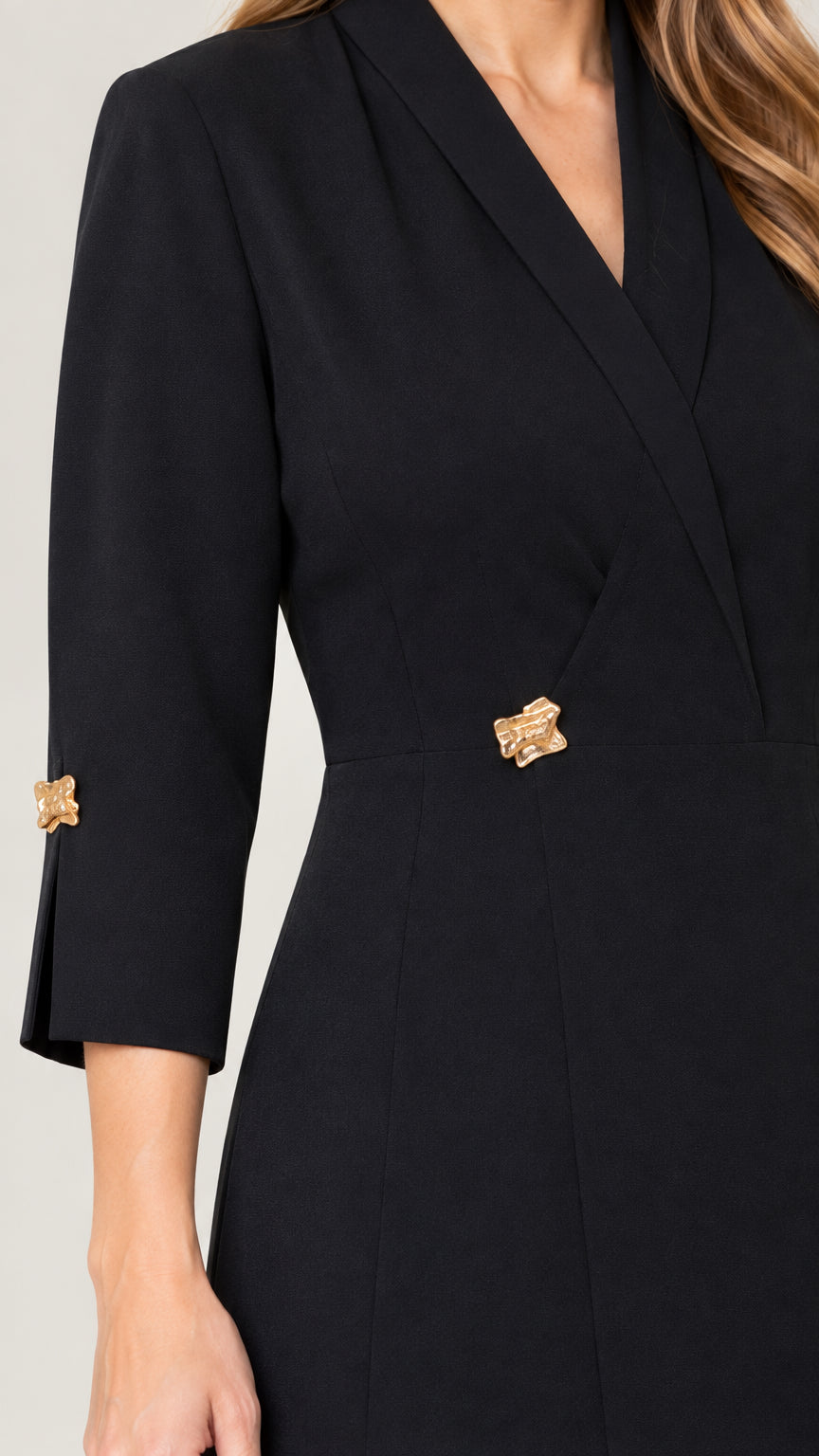 Close-up detail of lapel neckline, gold waist hardware, and gold buttoned sleeve cuffs