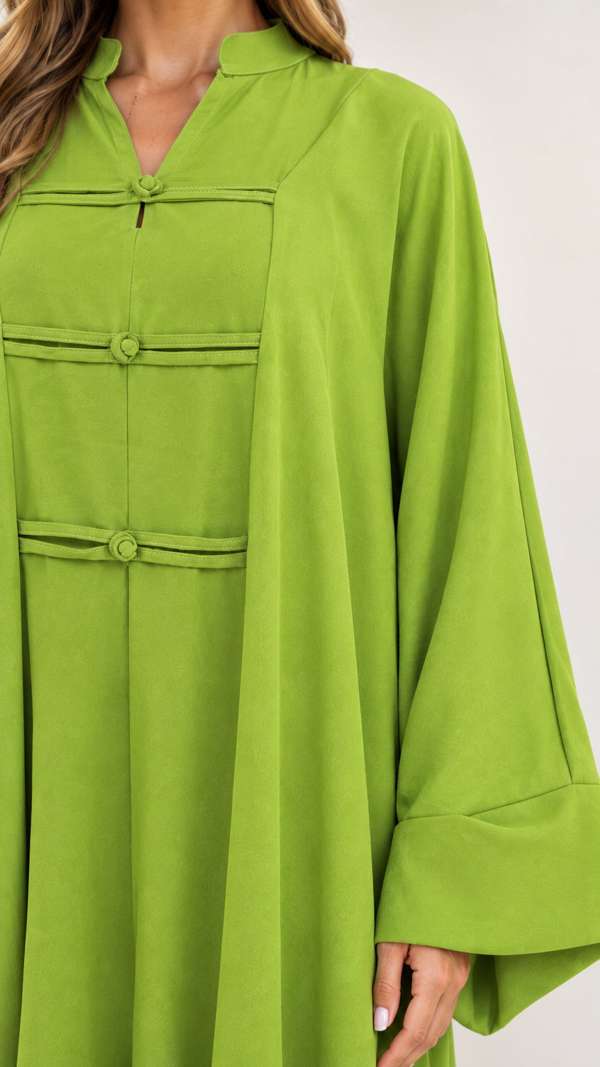 Close-up detail of mandarin collar and traditional oriental frog button closures on green dress