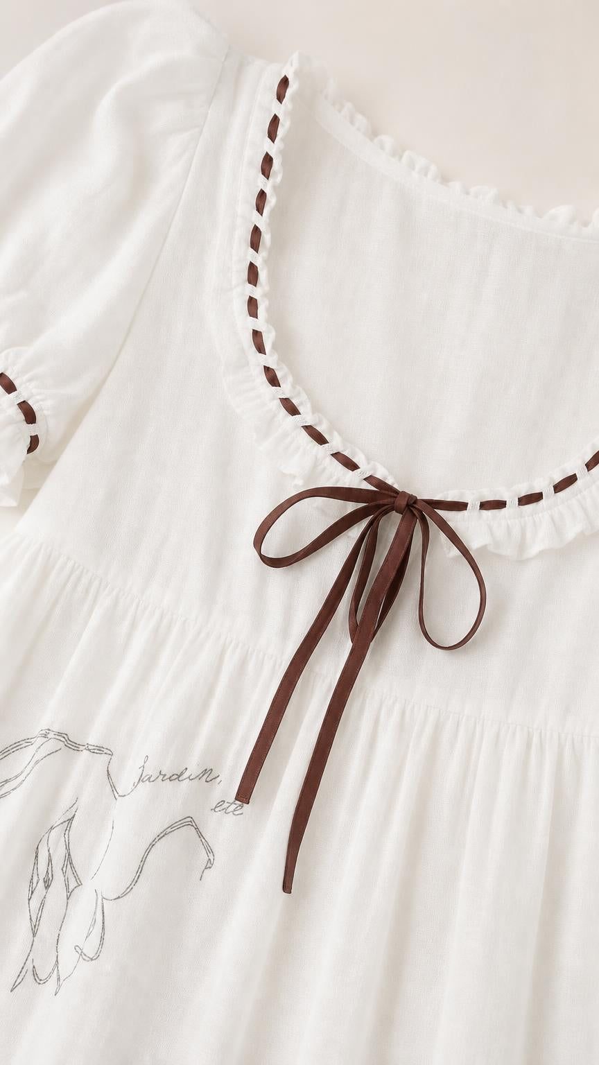 Close-up of neckline, ribbon tie, and embroidery details