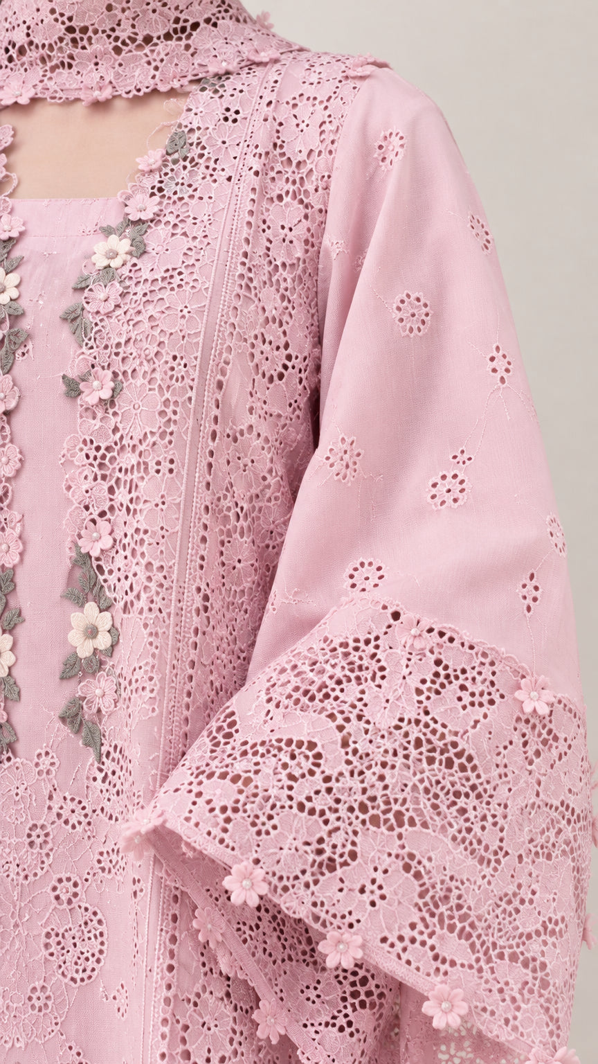 Close-up detail of blush pink eyelet lace fabric and 3D floral embroidery on sleeve and neckline