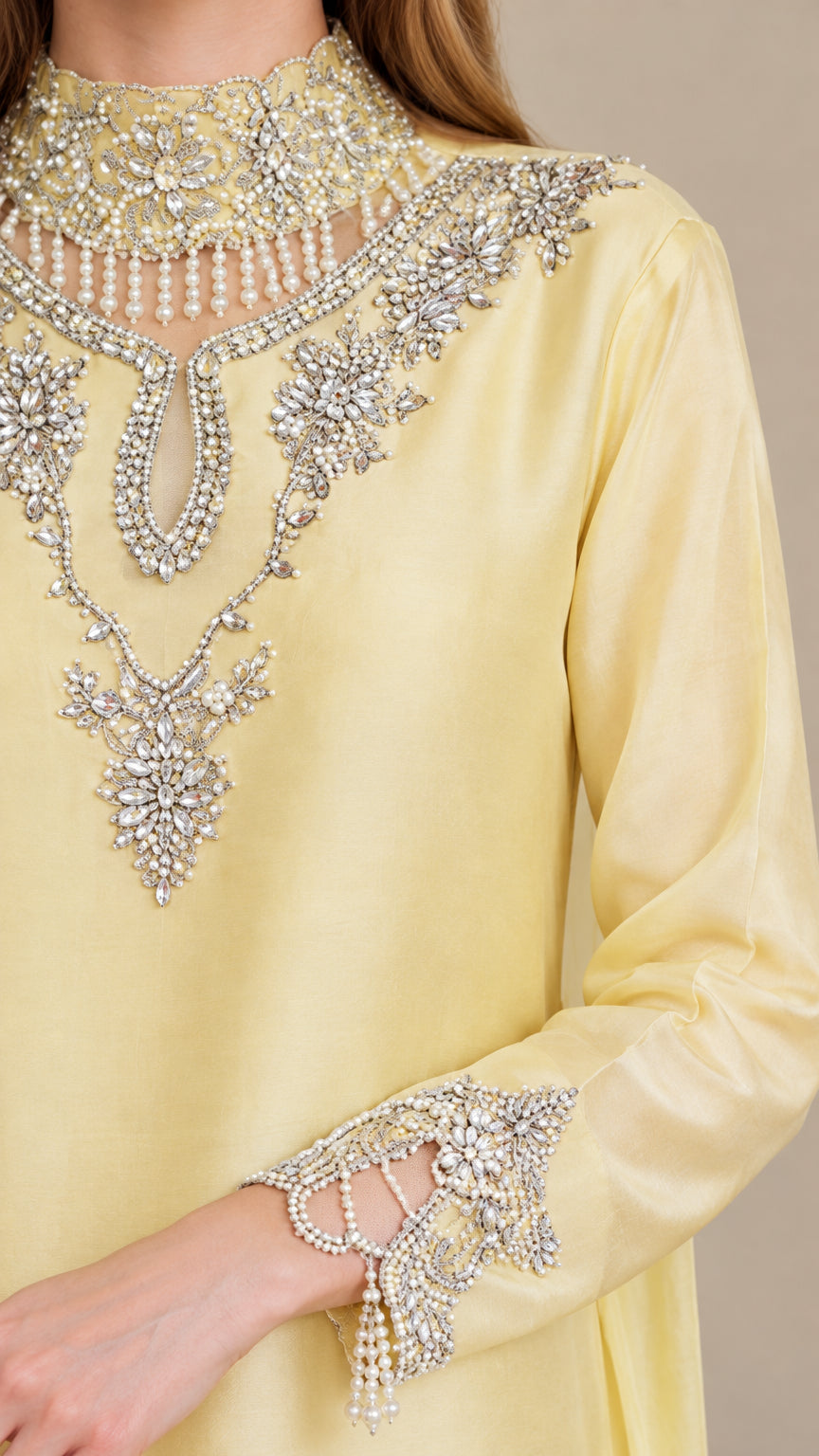 Close-up of intricate crystal beadwork and embroidery on neckline and sleeve cuffs