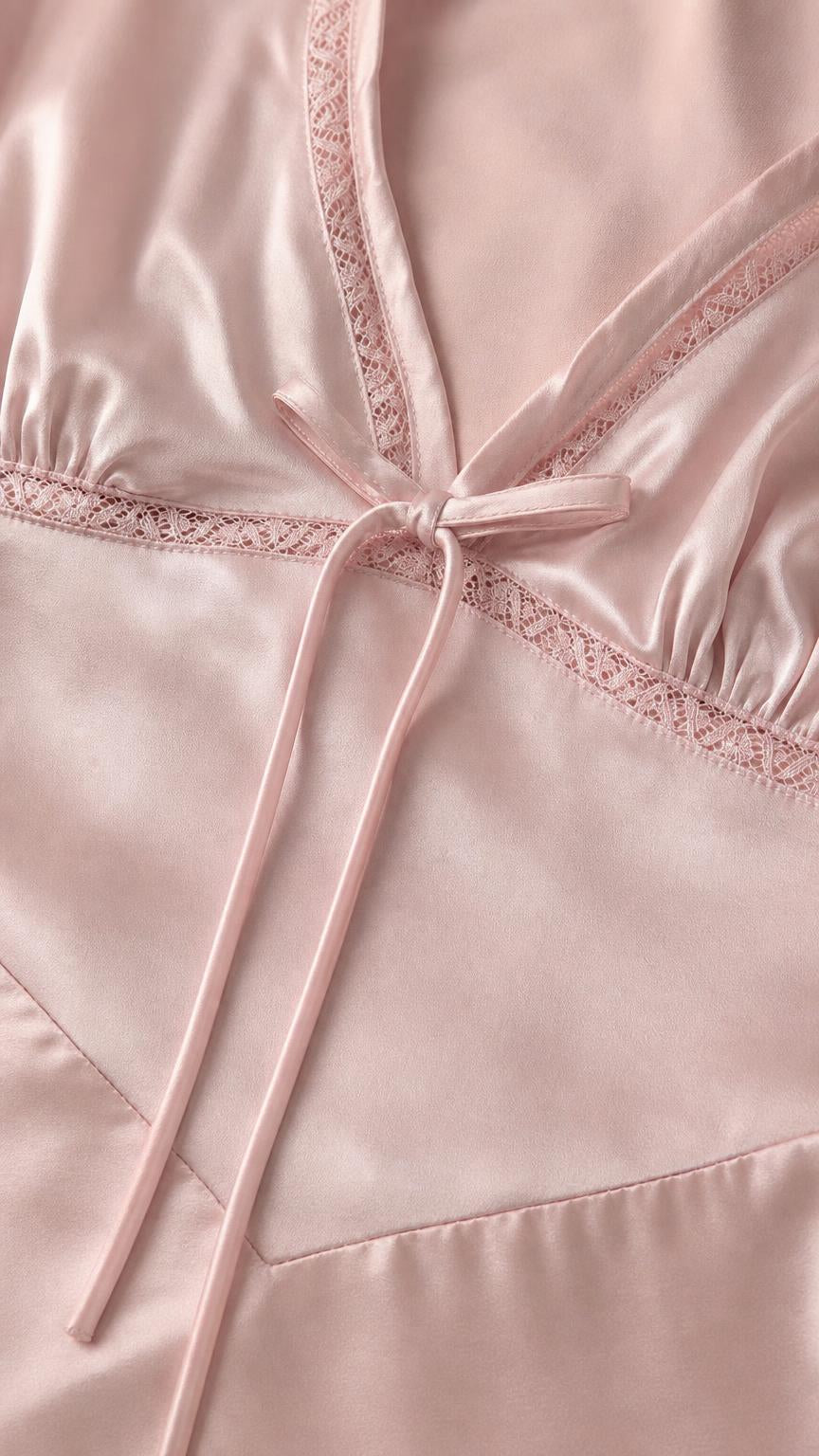 Close up of lace trim and tie detail on pink dress