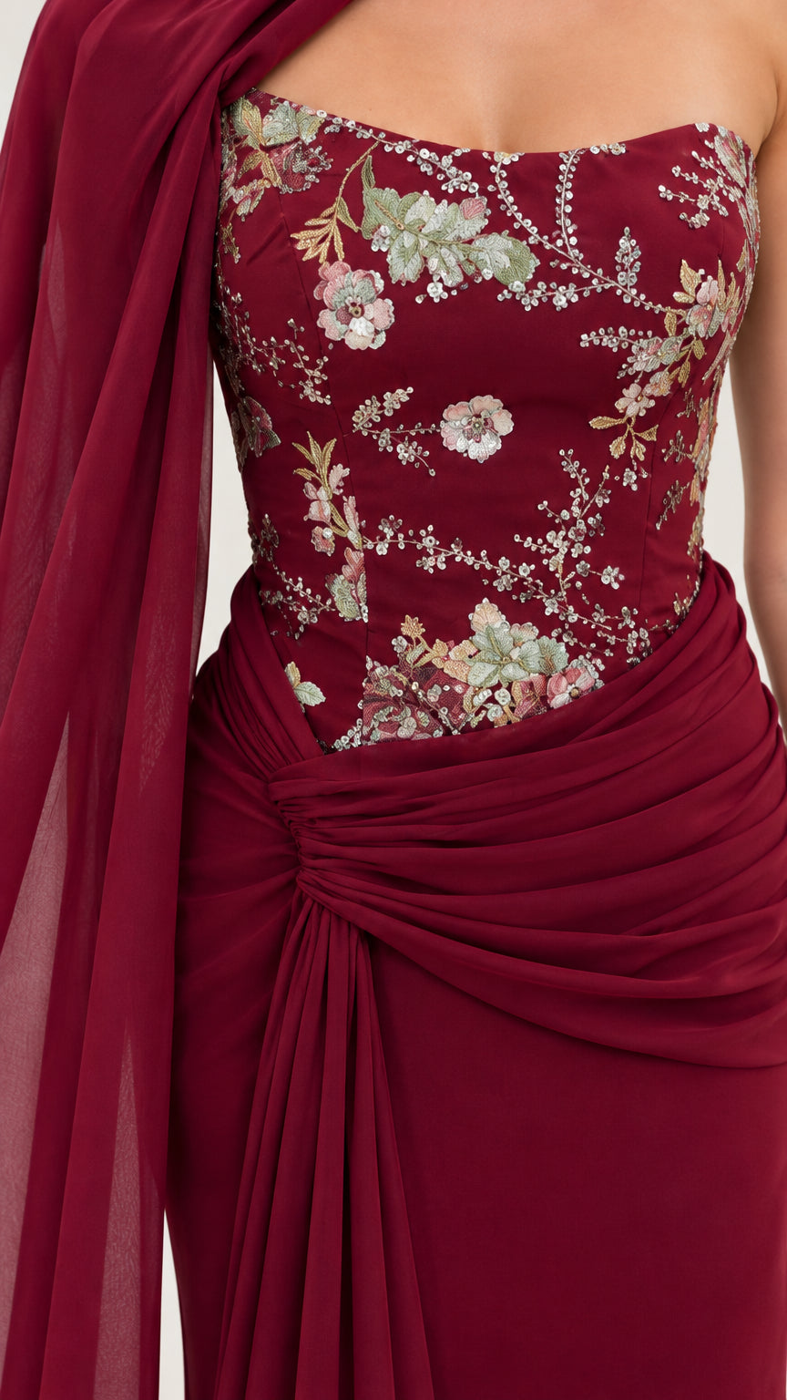 Close-up detail of burgundy floral embroidered bodice with side-gathered waist draping