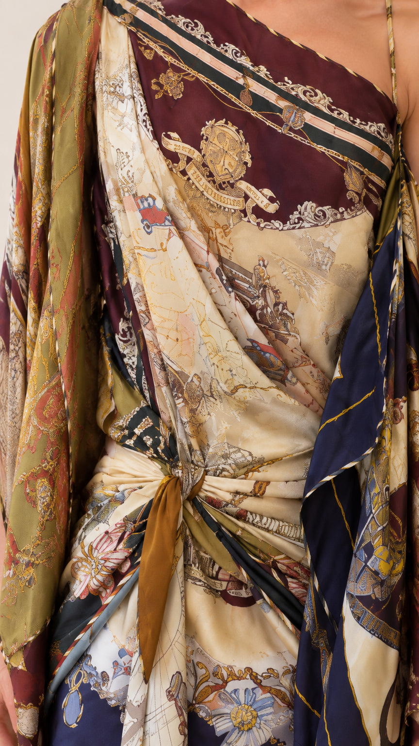 Close-up detail of knotted waist tie and intricate crest scarf print pattern