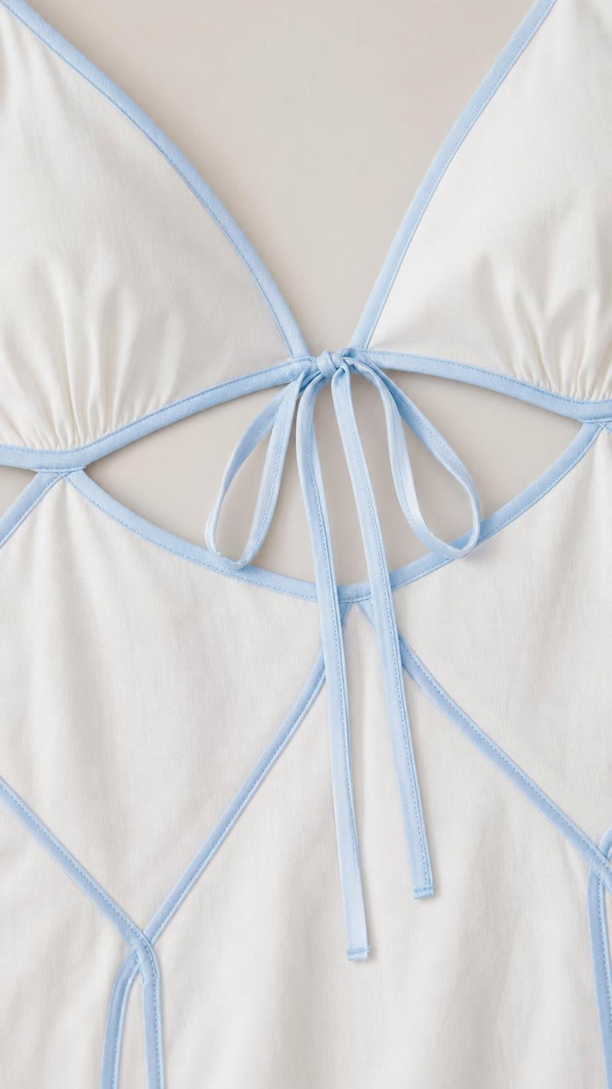 Close-up detail of front tie closure and contrast piping on the dress bodice