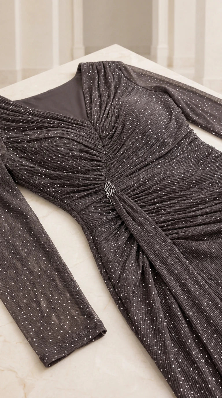 Close-up detail of Charcoal sparkly fabric, V-neckline, pleating, and crystal brooch accent