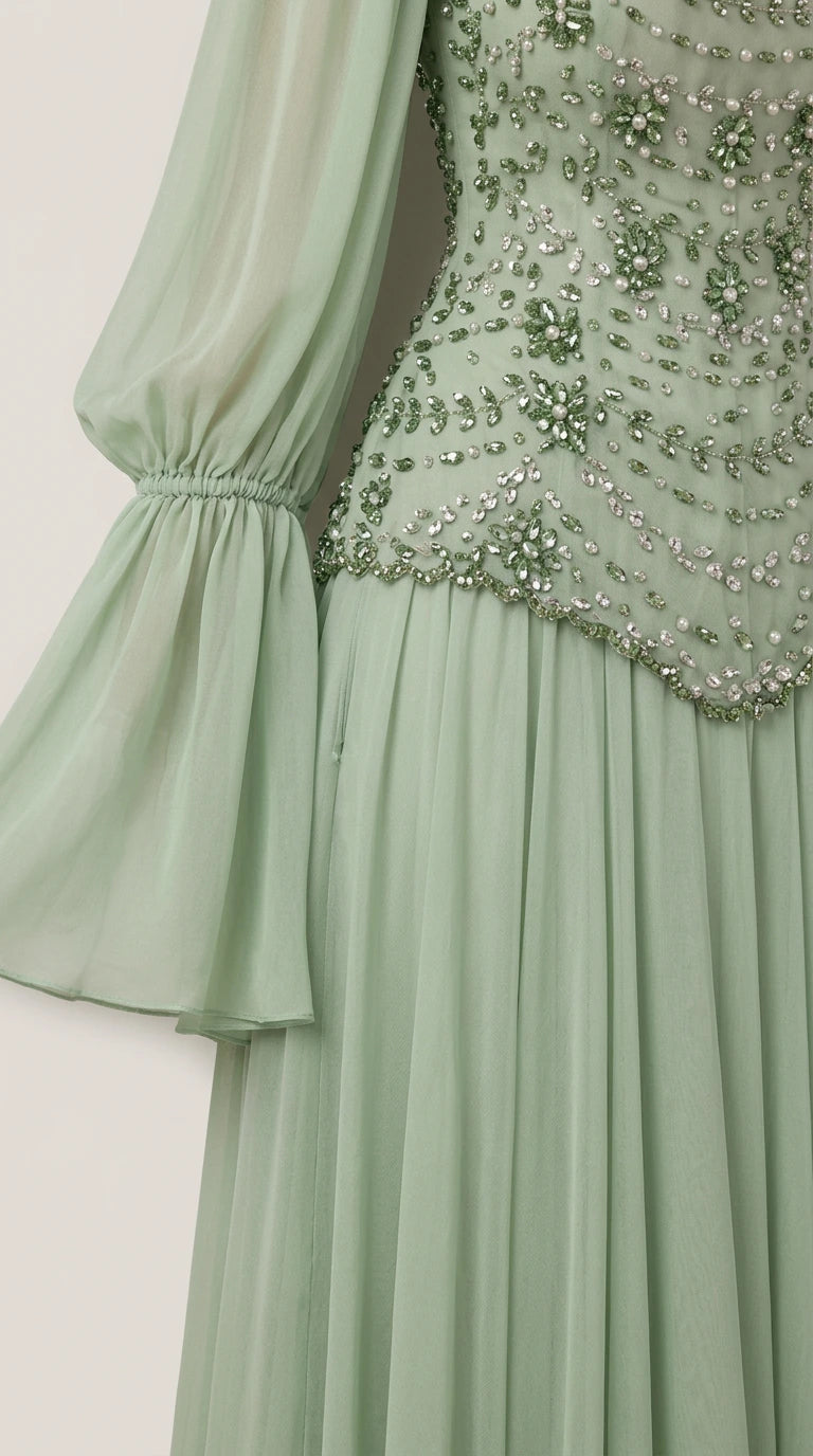 Close-up detail of intricate beadwork on bodice and flared chiffon sleeve cuff in sage green