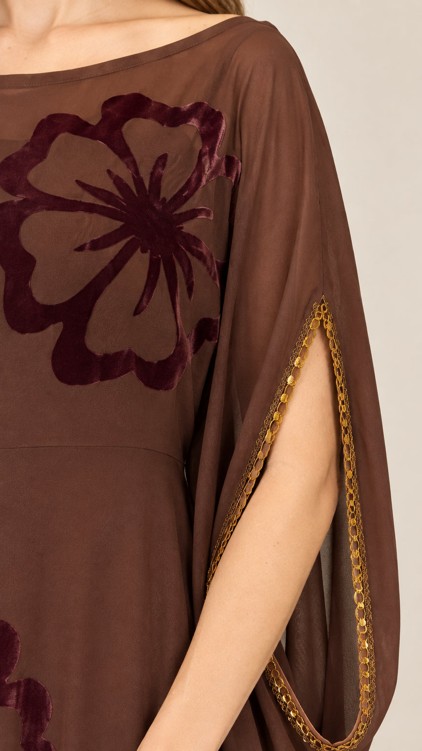 Close-up detail of velvet floral applique and metallic trim on split sleeve