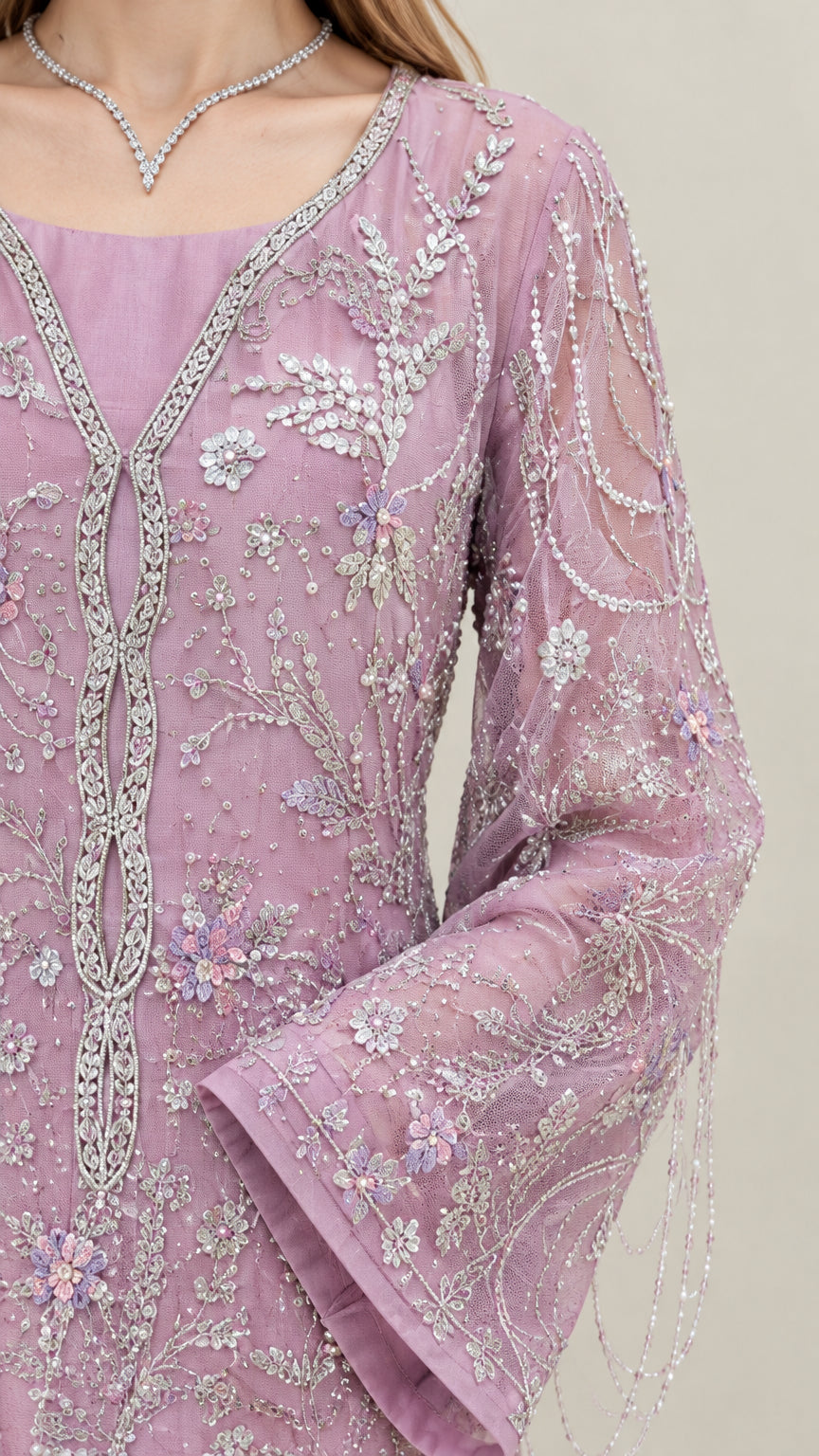 Close-up detail of intricate floral embroidery, sequins, and beaded sleeve fringe on lilac gown