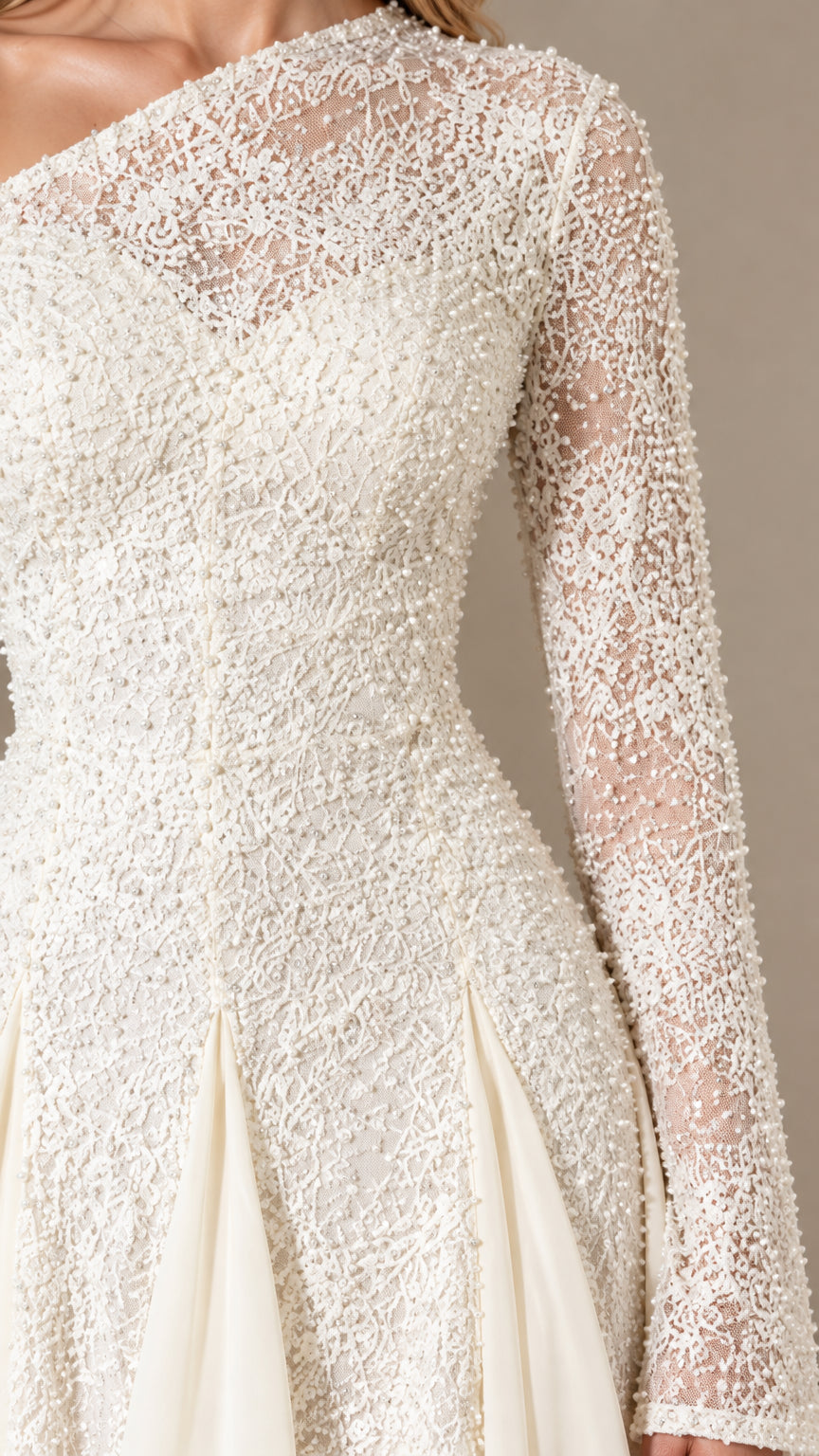 Close-up detail of textured beadwork and sheer lace sleeve on Ivory gown