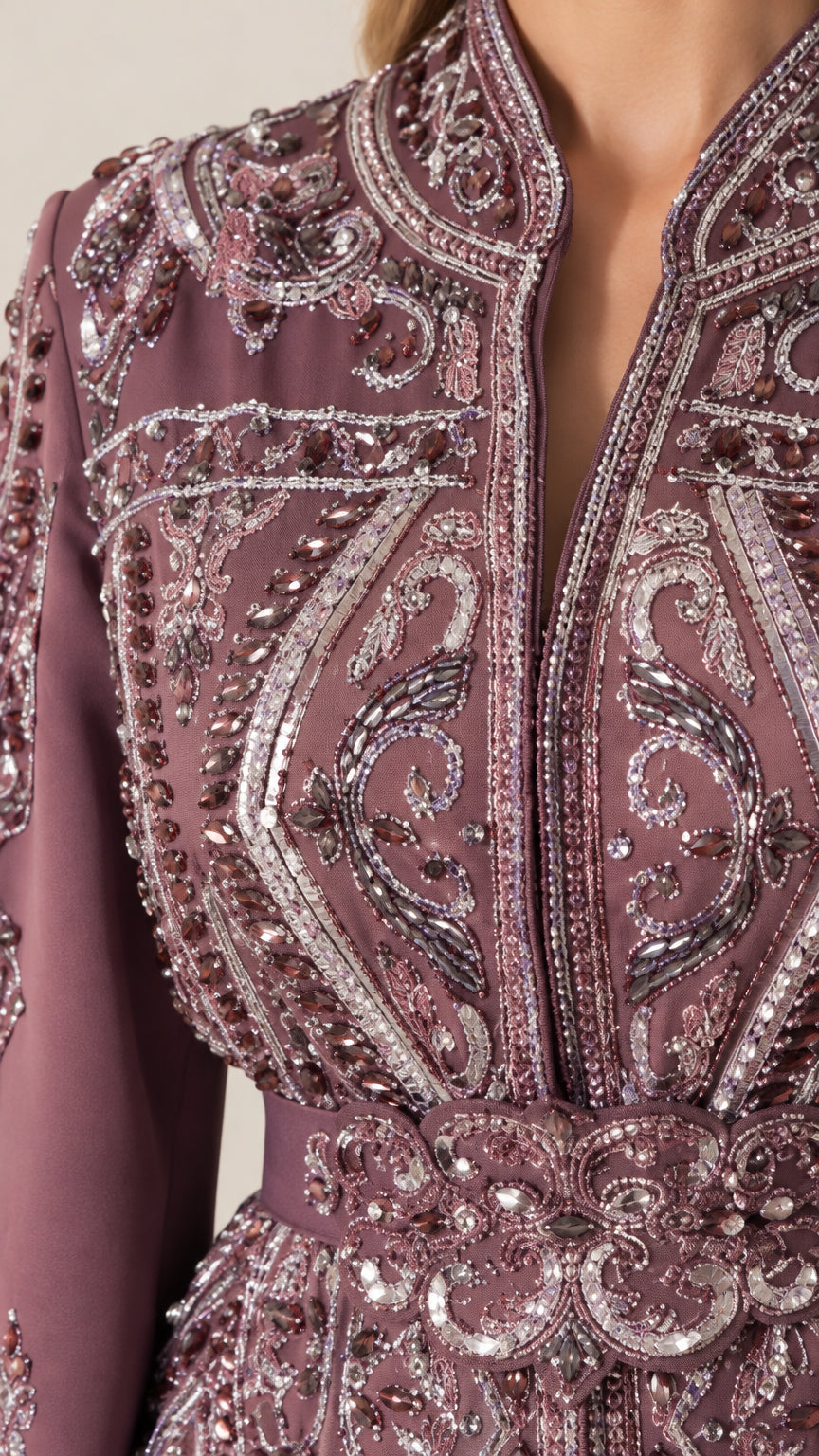 Close-up of intricate sequin beadwork and neckline embroidery on plum kaftan