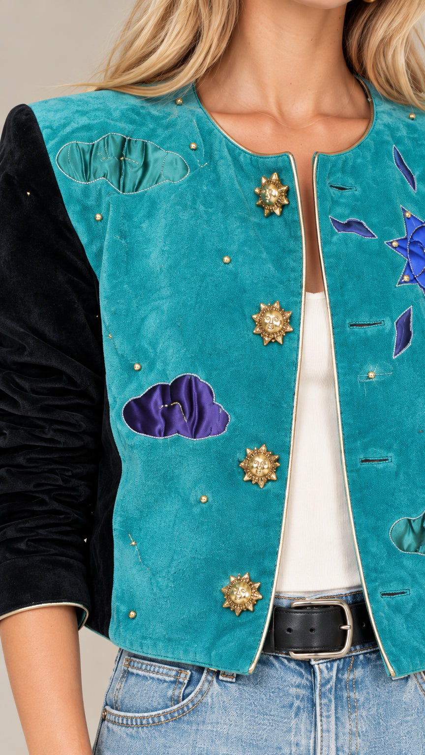 Close up view of teal celestial cropped jacket showing sunburst buttons, cloud appliques, and velvet sleeve