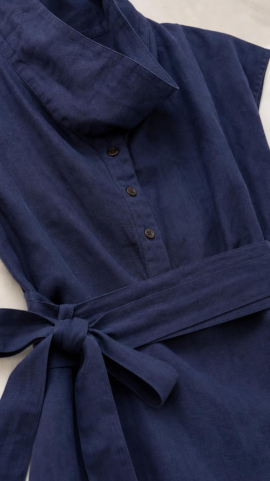 Close-up detail of cowl neck and button placket on navy jumpsuit