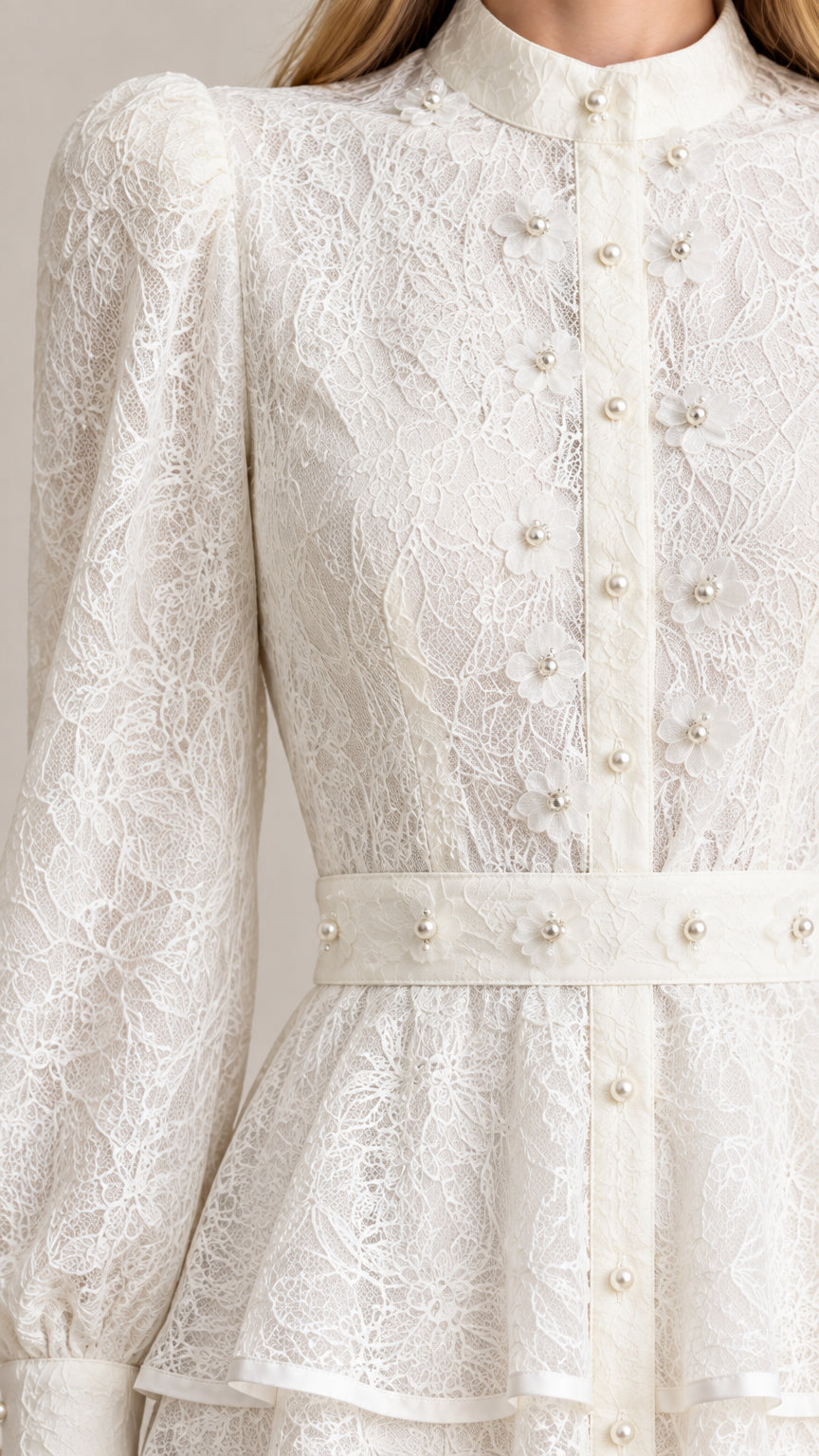Close-up detail of bodice showing floral lace pattern, pearl buttons, and embellished waistband
