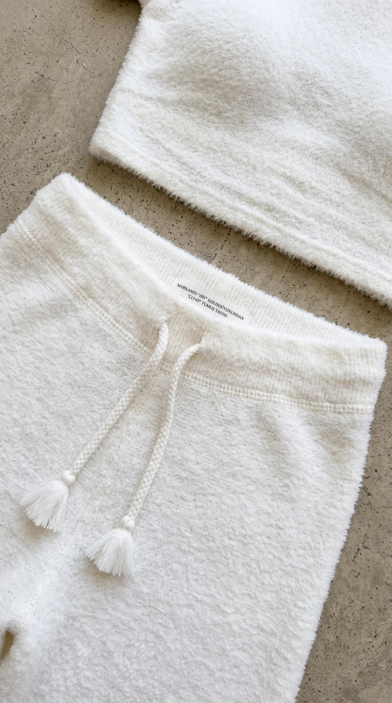 Close-up detail of plush fuzzy knit texture and tassel drawstring waistband in white