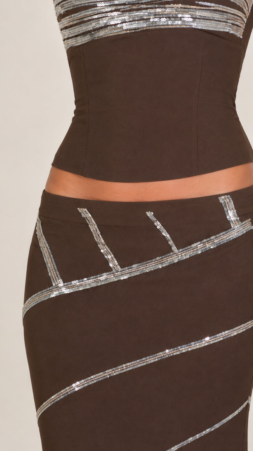 Close-up detail of sequin band trim on chocolate brown bodice and skirt