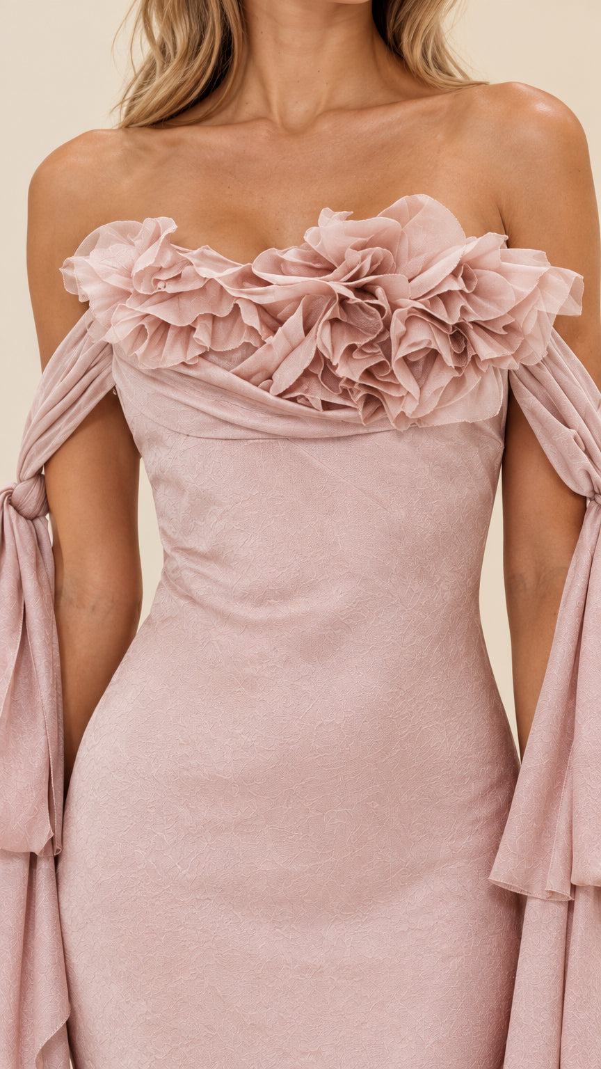 Close-up of 3D floral rosette appliqué and draped sleeve detail
