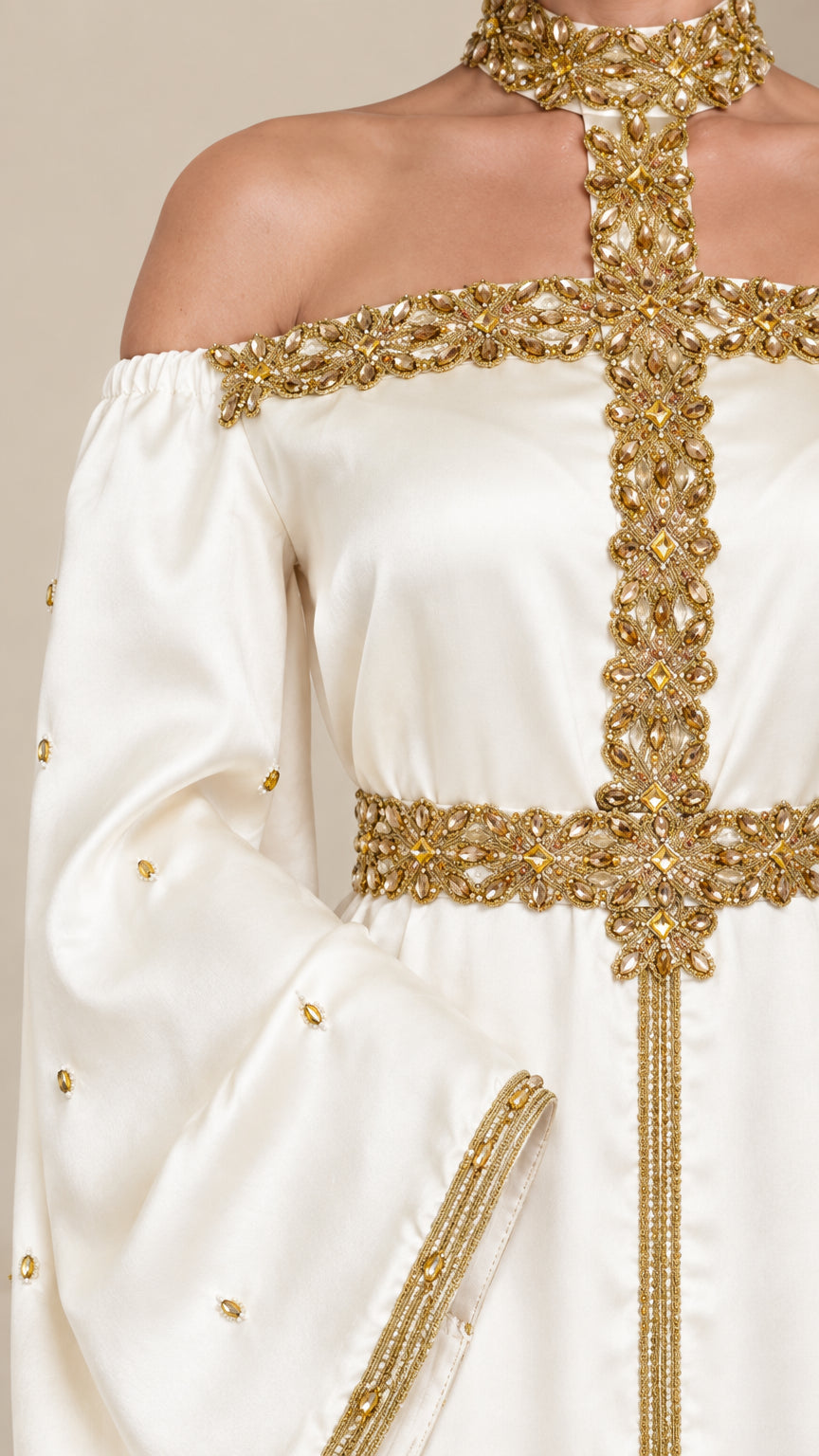 Close-up detail of ornate gold beadwork and halter neckline on ivory satin dress