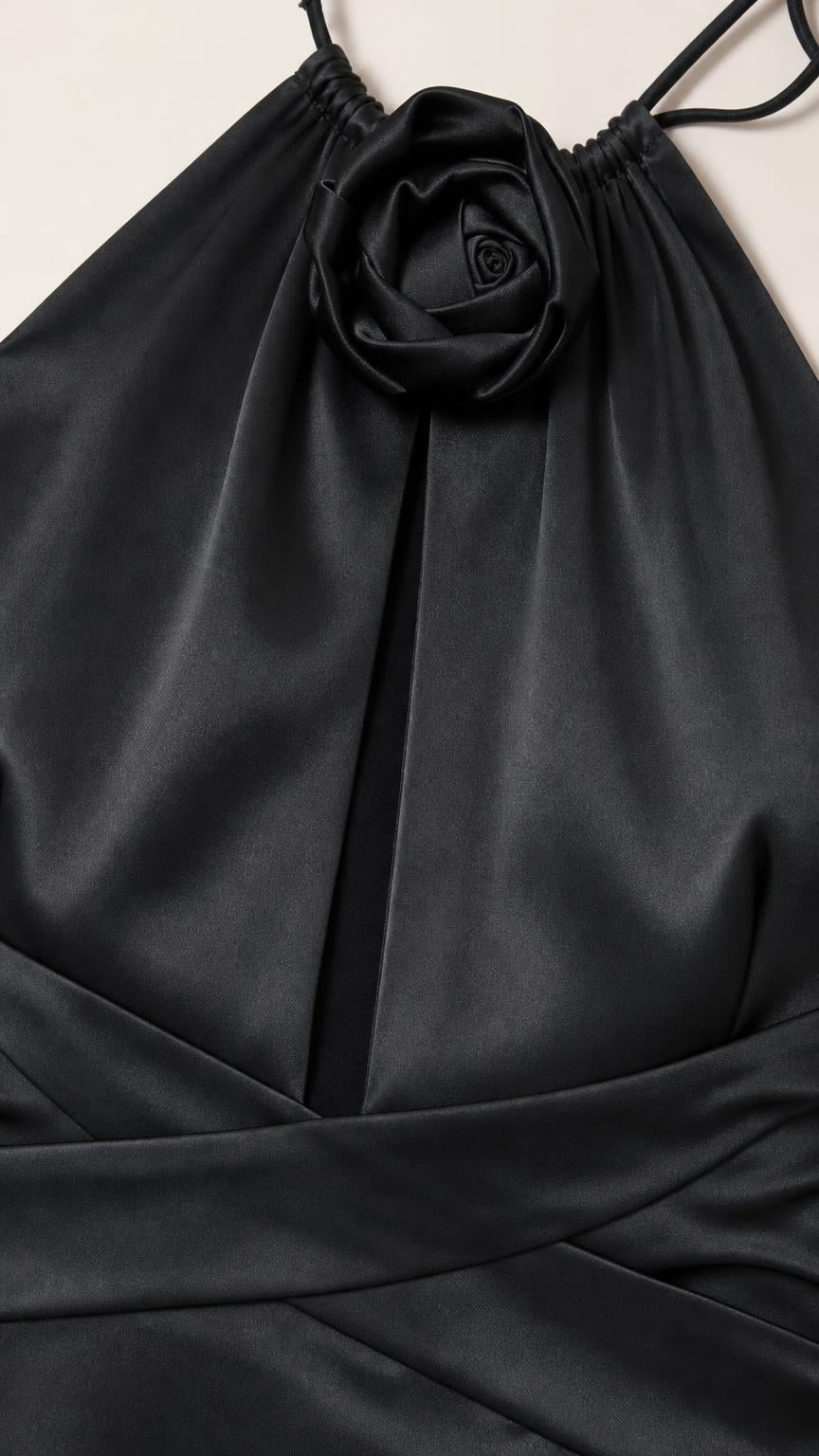 Close-up detail of front rosette and keyhole cutout on black satin dress
